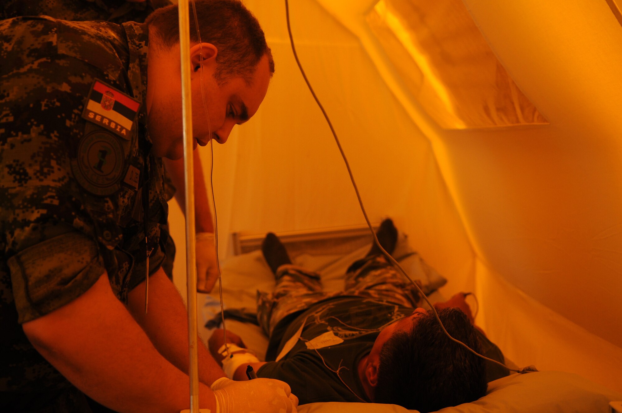 CAMP PEPELISHTE, Macedonia -- Maj. (Dr.) Dejan Zelkovic, Serbian Military Medical Academy surgeon, writes down a simulated patient's status during the 2011 Medical Training Exercise in Central and Eastern Europe live exercise June 11. An annual Chairman of the Joint Chiefs of Staff-sponsored regional and multilateral exercise, MEDCEUR is designed to provide medical training and operational experience in a deployed environment for U.S. and partner nations. The countries participating in this year's MEDCEUR are Macedonia, Montenegro, Bosnia and Herzegovina, Serbia, Slovenia and Norway. (U.S. Air Force photo/Staff Sgt. Julius Delos Reyes)