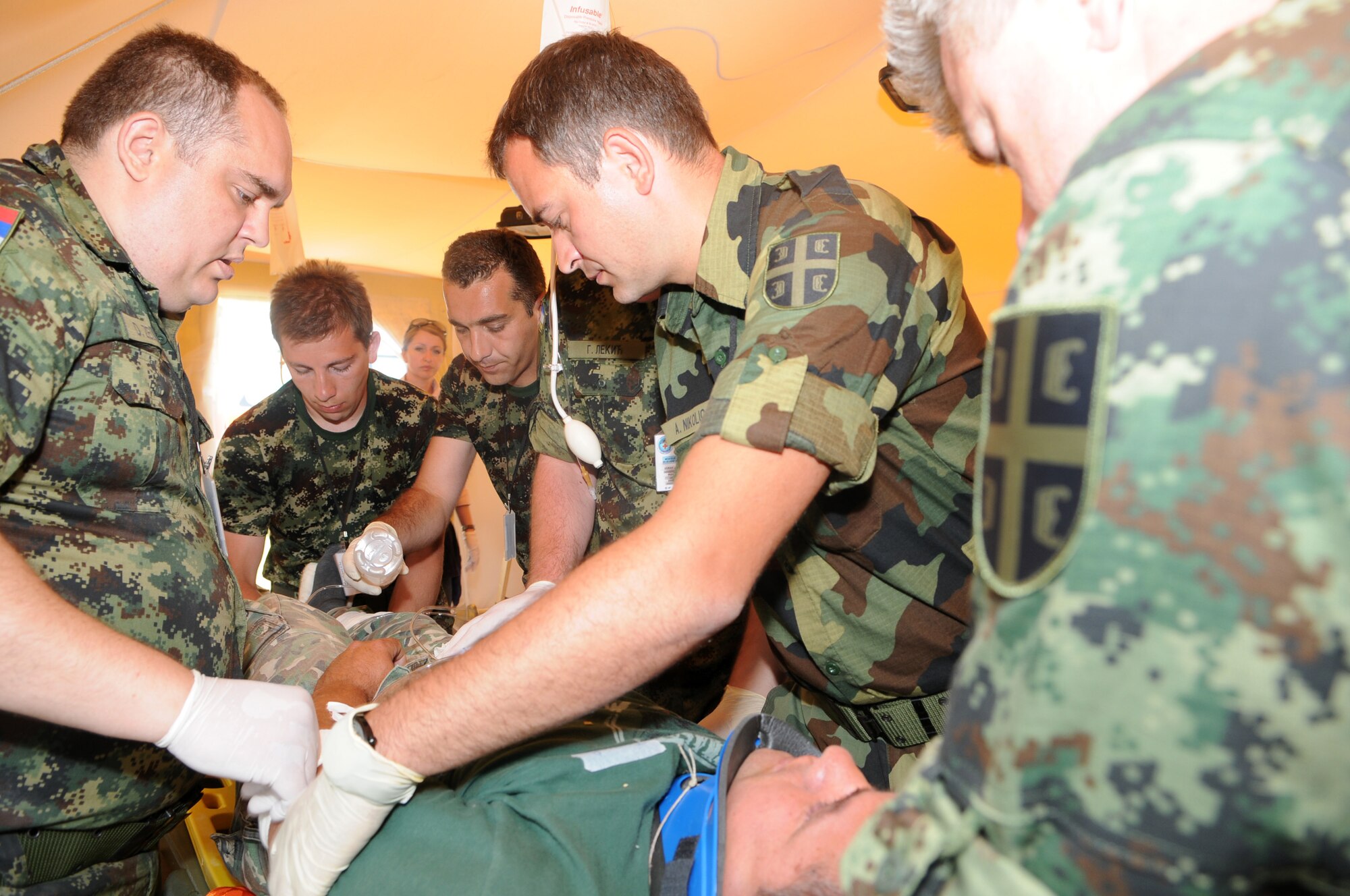 CAMP PEPELISHTE, Macedonia -- Serbian medical personnel check a patient for simulated trauma during the 2011 Medical Training Exercise in Central and Eastern Europe live exercise June 11. An annual Chairman of the Joint Chiefs of Staff-sponsored regional and multilateral exercise, MEDCEUR is designed to provide medical training and operational experience in a deployed environment for U.S. and partner nations. The countries participating in this year's MEDCEUR are Macedonia, Montenegro, Bosnia and Herzegovina, Serbia, Slovenia and Norway. (U.S. Air Force photo/Staff Sgt. Julius Delos Reyes)