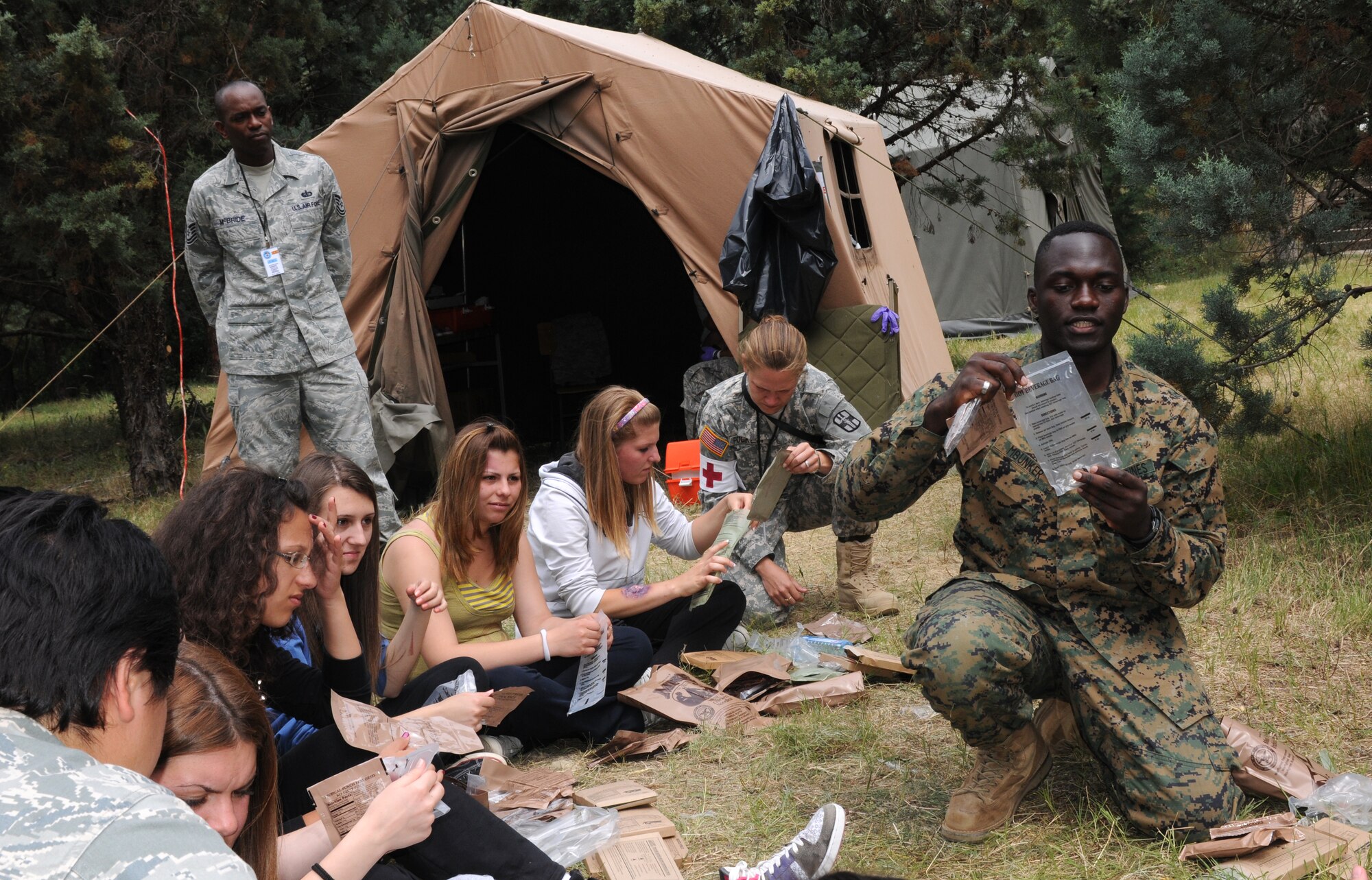 CAMP PEPELISHTE, Macedonia – U.S. Marine Staff Sgt. Tresor Mbunker, 4th Logistics Group, Personnel Retrieval Process Company mortuary affairs staff NCO in charge, demonstrates how to cook and use the items found in a Meal, Ready to Eat to local Macedonian students who volunteered to be “victims” of a simulated car accident or building and bridge collapse as part of a medical emergency response exercise during the 2011 Medical Training Exercise in Central and Eastern Europe June 11.  Macedonian students and U.S. service members were moulaged to make the exercises more realistic. The countries participating in this year’s MEDCEUR are Macedonia, Montenegro, Bosnia and Herzegovina, Serbia, Slovenia and Norway. MEDCEUR is a Partnership for Peace and Chairman of the Joint Chiefs of Staff-sponsored regional and multilateral exercise in Central and Eastern Europe designed to provide medical training and operational experience in a deployed environment.  (U.S. Air Force photo/Master Sgt. Kelley J. Stewart)