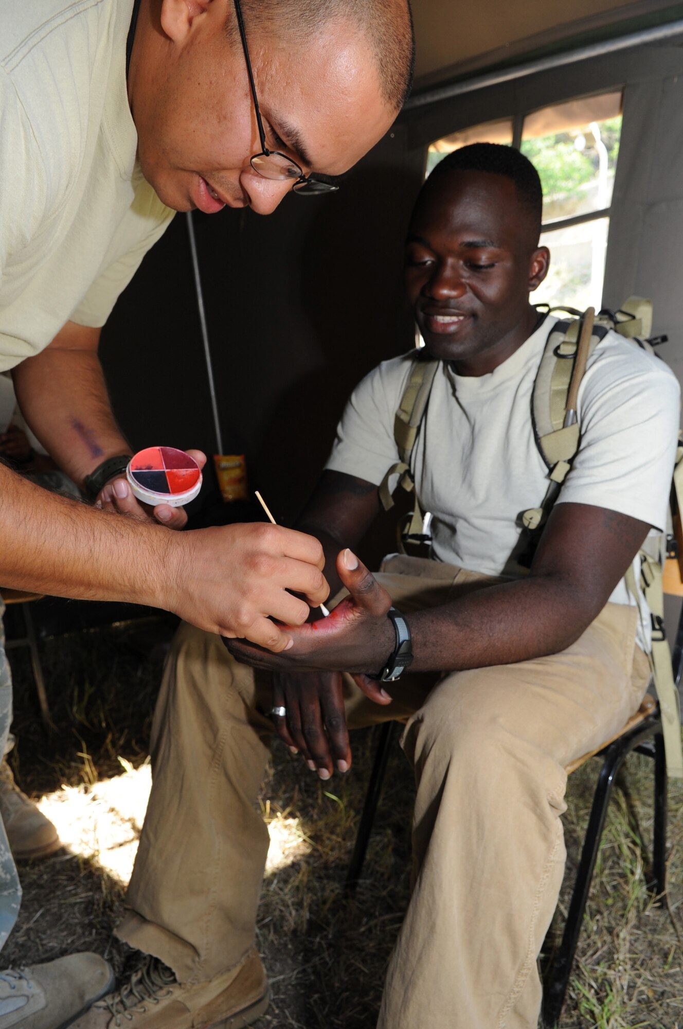 CAMP PEPELISHTE, Macedonia ? Left, Staff Sgt. Ezquiel Villarreal, 882nd Training Squadron medical readiness instructor from Camp Bullis, Texas, applies moulage patient the U.S. Marine Staff Sgt. Tresor Mbunker, 4th Logistics Group, Personnel Retrieval and Processing Company mortuary affairs staff NCO in charge from Smyrna, Ga., as part of a simulated natural disaster during the 2011 Medical Training Exercise in Central and Eastern Europe live exercise June 11. An annual Chairman of the Joint Chiefs of Staff-sponsored regional and multilateral exercise, MEDCEUR is designed to provide medical training and operational experience in a deployed environment for U.S. and partner nations. The countries participating in this year's MEDCEUR are Macedonia, Montenegro, Bosnia and Herzegovina, Serbia, Slovenia and Norway. (U.S. Air Force photo/Staff Sgt. Nadine Y. Barclay)