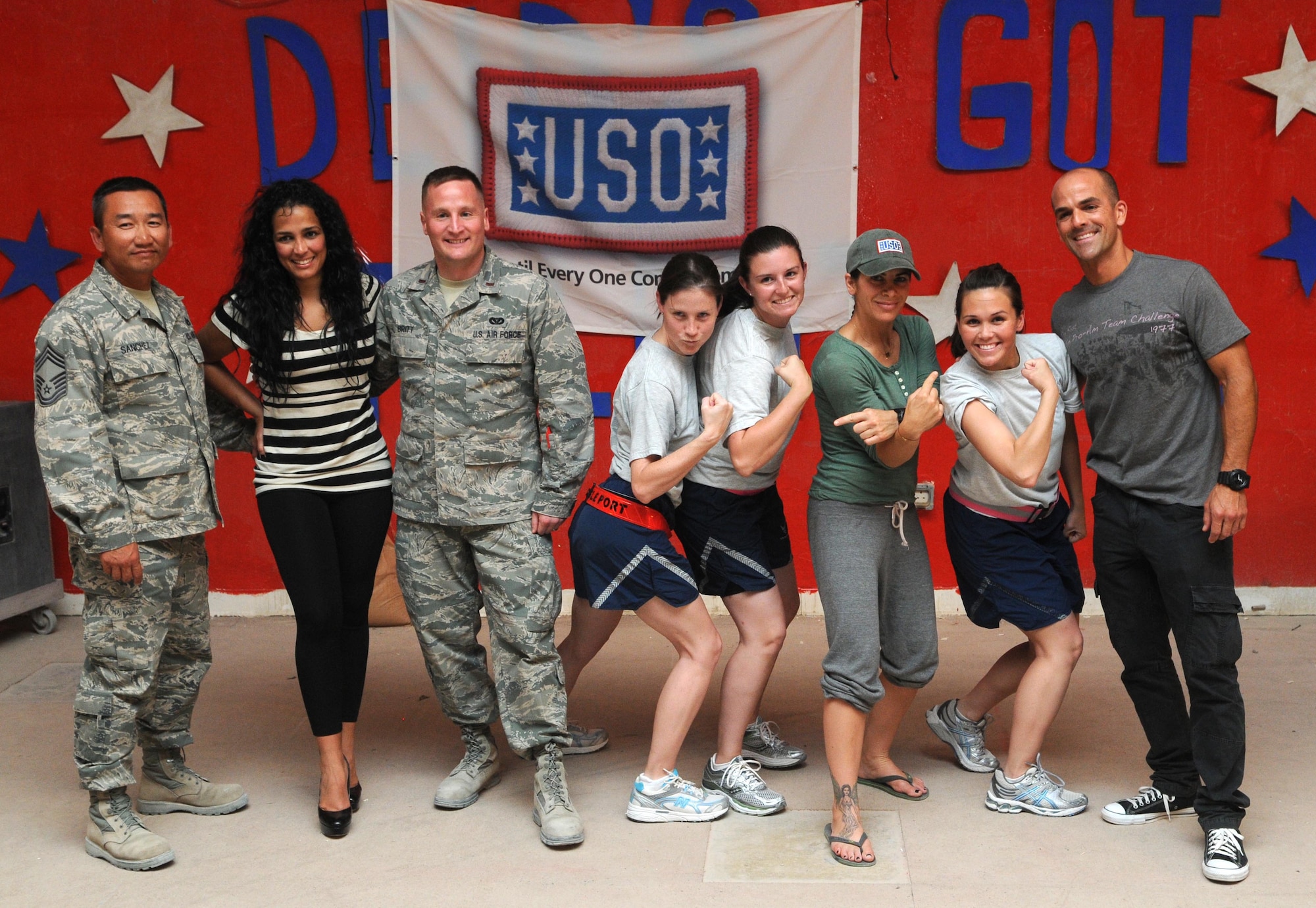 Servicemembers from the 379th Air Expeditionary Wing pose for a photo with Celines Toribio, Jillian Michaels, and Marco Borges June 10 in Southwest Asia. Ms. Michaels, Mrs. Toribio and Mr. Borges were apart of the first USO Fitness Tour. (U.S. Air Force photo/ Staff Sgt. Anthony Graham)