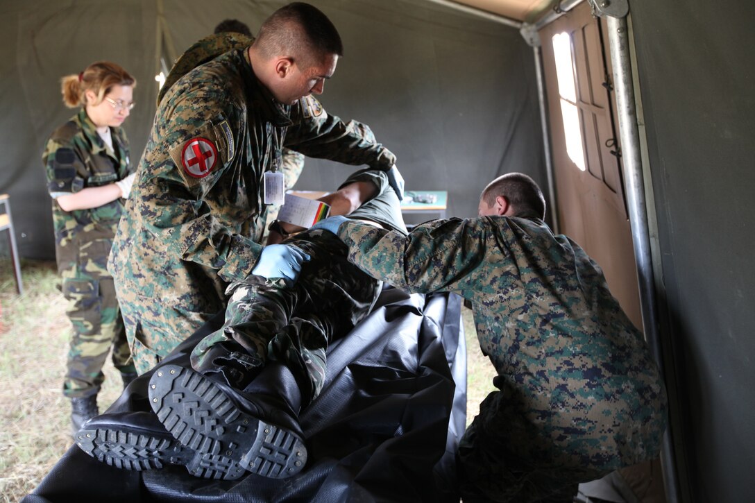 Jordance Stanotkovski, Macedonian Quick Response Force policeman, assists his fellow Macedonian policeman with the processing of simulated human remains, June 12. The Marines from Personnel and Retrieval Processing Company, 4th Marine Logistics Group, out of Smyrna, Ga. and Anacostia, Washington D.C., came to Macedonia for 2011 Medical Training Exercise in Central and Eastern Europe to teach foreign military services how the U.S. military conducts mortuary affairs. MEDCEUR is an annual Chairman of the Joint Chiefs of Staff-sponsored regional and multilateral exercise and is designed to provide medical training and operational experience in a deployed environment for U.S. and partner nations. The countries participating in this year’s MEDCEUR are Macedonia, Montenegro, Bosnia and Herzegovina, Serbia, Slovenia and Norway