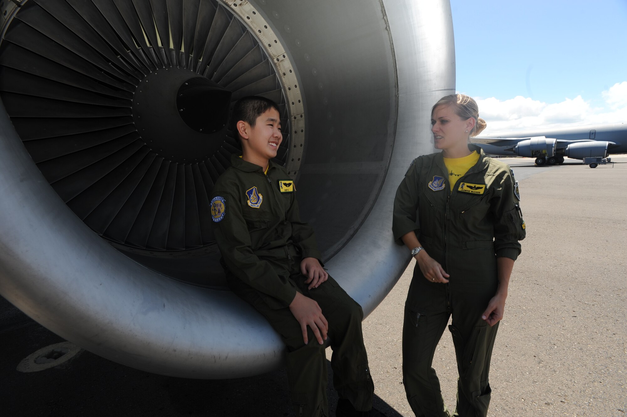 Cody Sugai  sits in the engine of a KC-135 and chats with Capt. Jasmine McCann, KC-135 pilot with the 96th Air Refueling Squadron, Cody's escort during his Pilot for a Day experience June 10. Cody is recovering from strokes caused by arteriovenous malformation and was nominated as the PFAD by Kapi'olani Medical Center in partnership with the 15th Wing. (U.S. Air Force photo/Senior Airman Lauren Main)