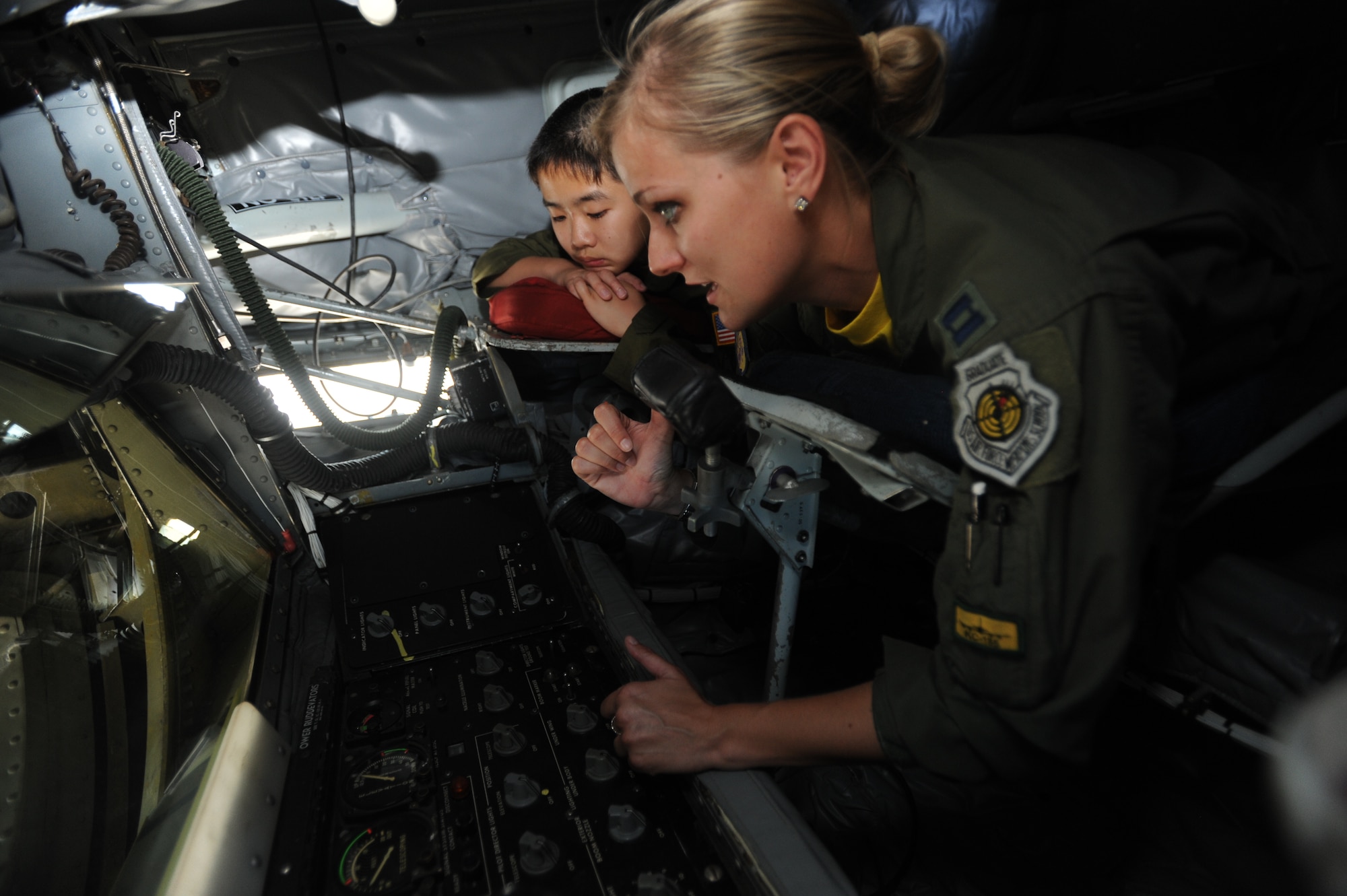 Capt. Jasmine McCann, KC-135 pilot with the 96th Air Refueling Squadron explains the controls in the boom to Cody Sugai June 10. Cody Sugai is this quarters "Pilot for a Day".  Cody is recovering from strokes caused by arteriovenous malformation and was nominated as the PFAD by Kapi'olani Medical Center in partnership with the 15th Wing. (U.S. Air Force photo/Senior Airman Lauren Main)