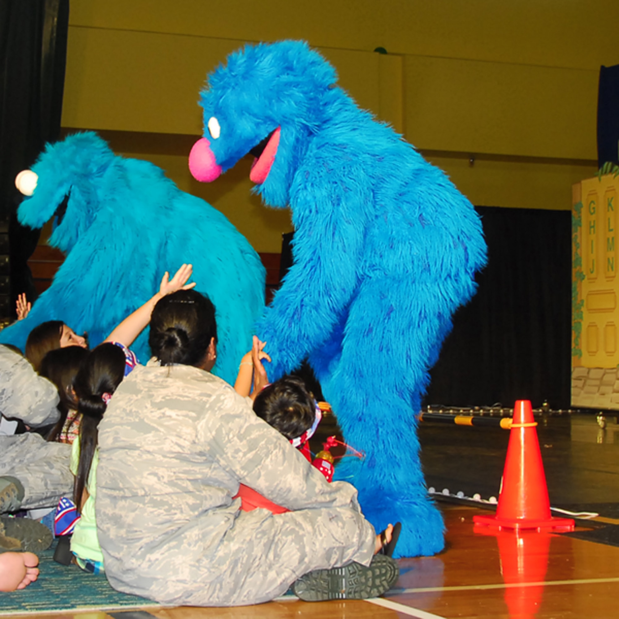 Muppets, Cookie Monster and Grover, greet audience members at a performance during a performance at the Youth Center gym here June 9. The United Service Organizations teamed with Sesame Workshop, the non-profit organization that produces Sesame Street, to bring The Sesame Street/USO Experience for Military Families to the Asia-Pacific region.(U.S. Air Force photo/Airman 1st Class Whitney Tucker)
