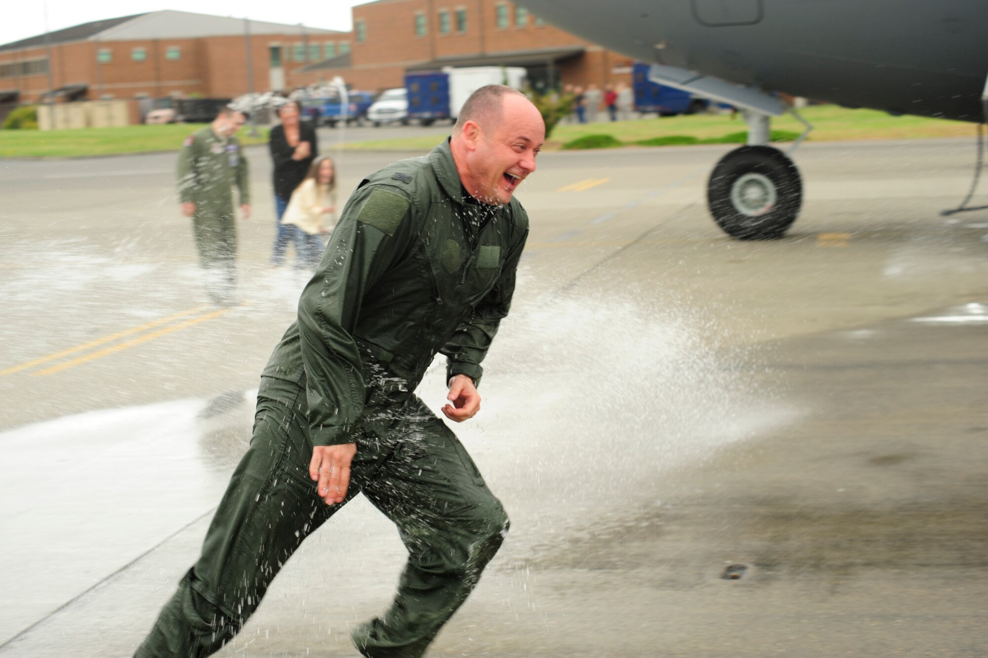 Col. Kevin Kilb, 62nd Airlift Wing commander, gets hosed down by his wife, Stacey, after completing his final flight at Joint Base Lewis-McChord June 8. Colonel Kilb will be retiring after more than 22 years of Air Force service. (U.S. Air Force photo/Adamarie Lewis-Page)