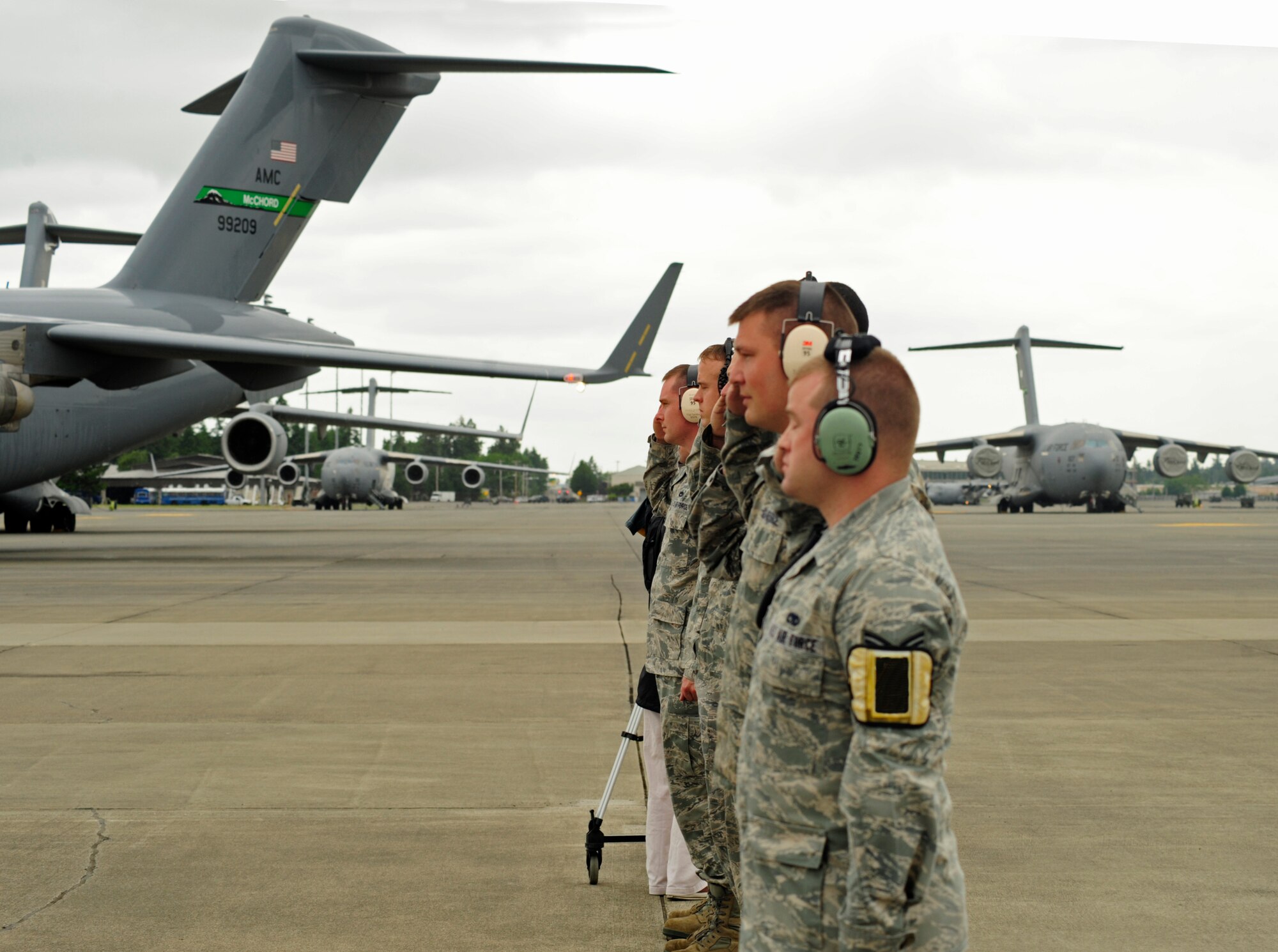 A group of Airmen salute as Col. Kevin Kilb, 62nd Airlift Wing commander, taxis a C-17 Globemaster III during his final flight at Joint Base Lewis-McChord June 8. (U.S. Air Force illustration/Adamarie Lewis-Page)