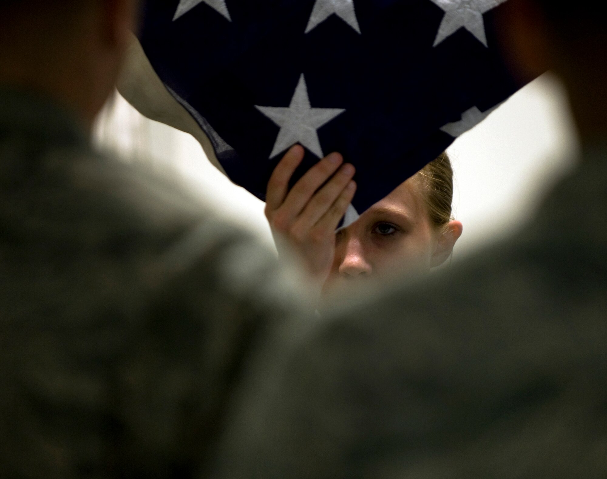 Honor Guardsman Airman 1st Class Rebecca Sobiech holds up the American flag during a mock funeral June 7, 2011, Eielson Air Force Base, Alaska.  Honor Guardsmen drill constantly to maintain the precision they are known for. The flag is folded 13 times and is then given to the next of kin. Each fold represents a different symbolic meaning.  Airman Sobiech is assigned to the 354th Comptroller Squadron. (U.S. Air Force photo/Airman 1st Class Laura Goodgame) 