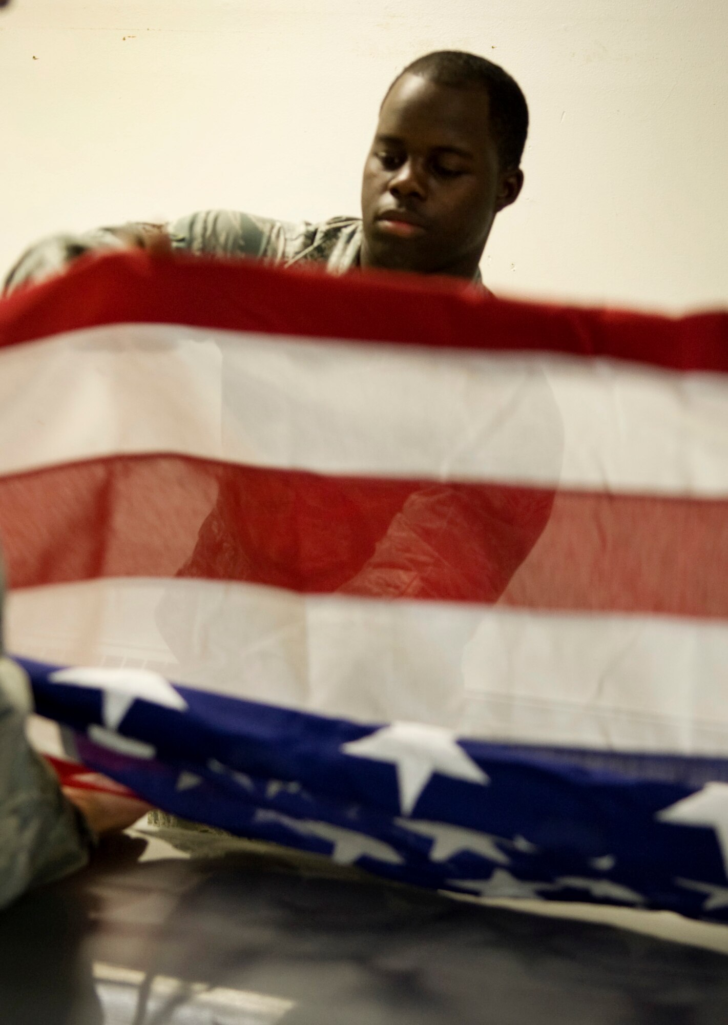Honor Guardsman Airman 1st Class Harvey Lee assists in folding the American flag during a practice June 7, 2011, Eielson Air Force Base, Alaska.  Honor Guard members train constantly to maintain the precision they are known for. The flag is folded 13 times; each fold is symbolic.  Airman Lee is assigned to the 354th Maintenance Squadron. (U.S. Air Force photo/Airman 1st Class Laura Goodgame) 