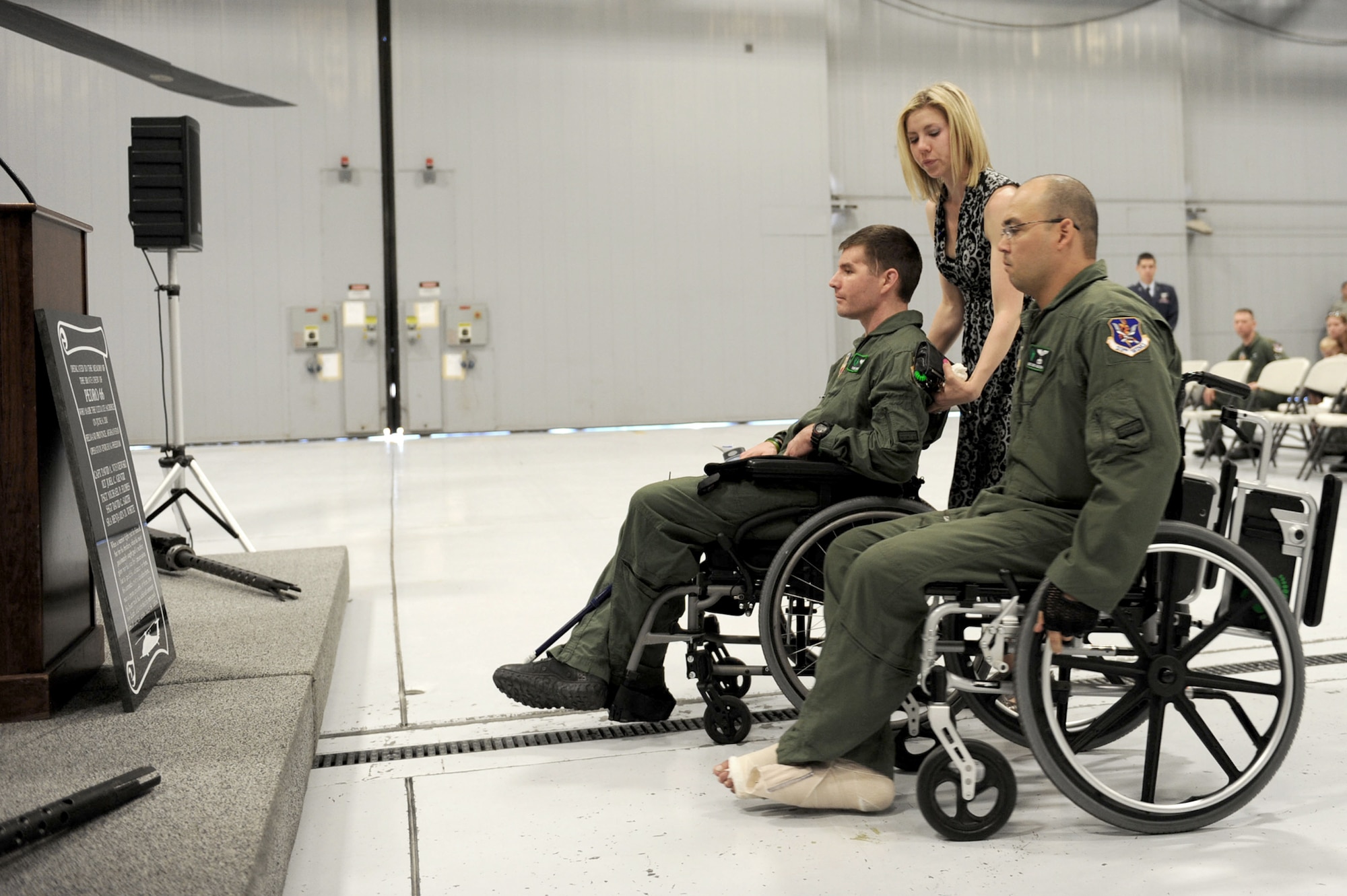 Capt. Anthony Simone, his wife Andrea and Master Sgt. Christopher Aguilera read the plaque that was unveiled June 9, 2011, during a memorial ceremony at Nellis Air Force Base, Nev., honoring crewmembers of Pedro 66.  Captain Simone and Sergeant Aguilera were critically injured when their HH-60G Pave Hawk helicopter, call sign Pedro 66, crashed in southwest Afghanistan June 9, 2010.  The other five crewmembers on board were killed. The helicopter was on a rescue mission supporting Operation Enduring Freedom at the time of the crash.  (U.S. Air Force photo/Staff Sgt. Taylor Worley)