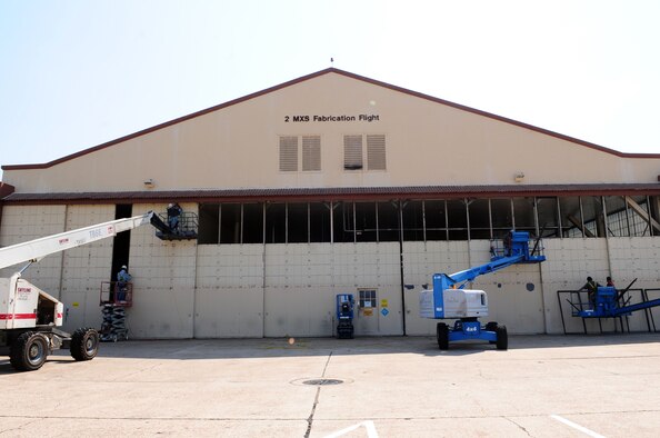 Local contractors remove painted windows that line the front of the 2nd Maintenance Squadron Fabrication Flight hangar located on Barksdale Air Force Base, La., June 13. The hangar windows are being replaced with a more eco-friendly alternative that will allow more light to filter into the hangar, which will lead to less energy consumption. (U.S. Air Force photo/Senior Airman Joanna M. Kresge)
