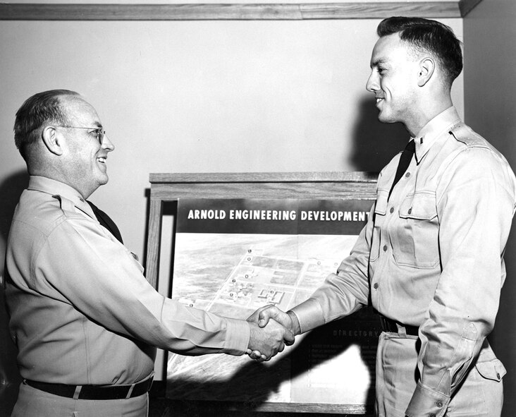 AEDC Vice Commander Col. William L. McCulla, shakes the hand of Lt. James Mitchell, after pinning the junior officer with his 1st lieutenant bars in 1955. (AEDC File Photo)
