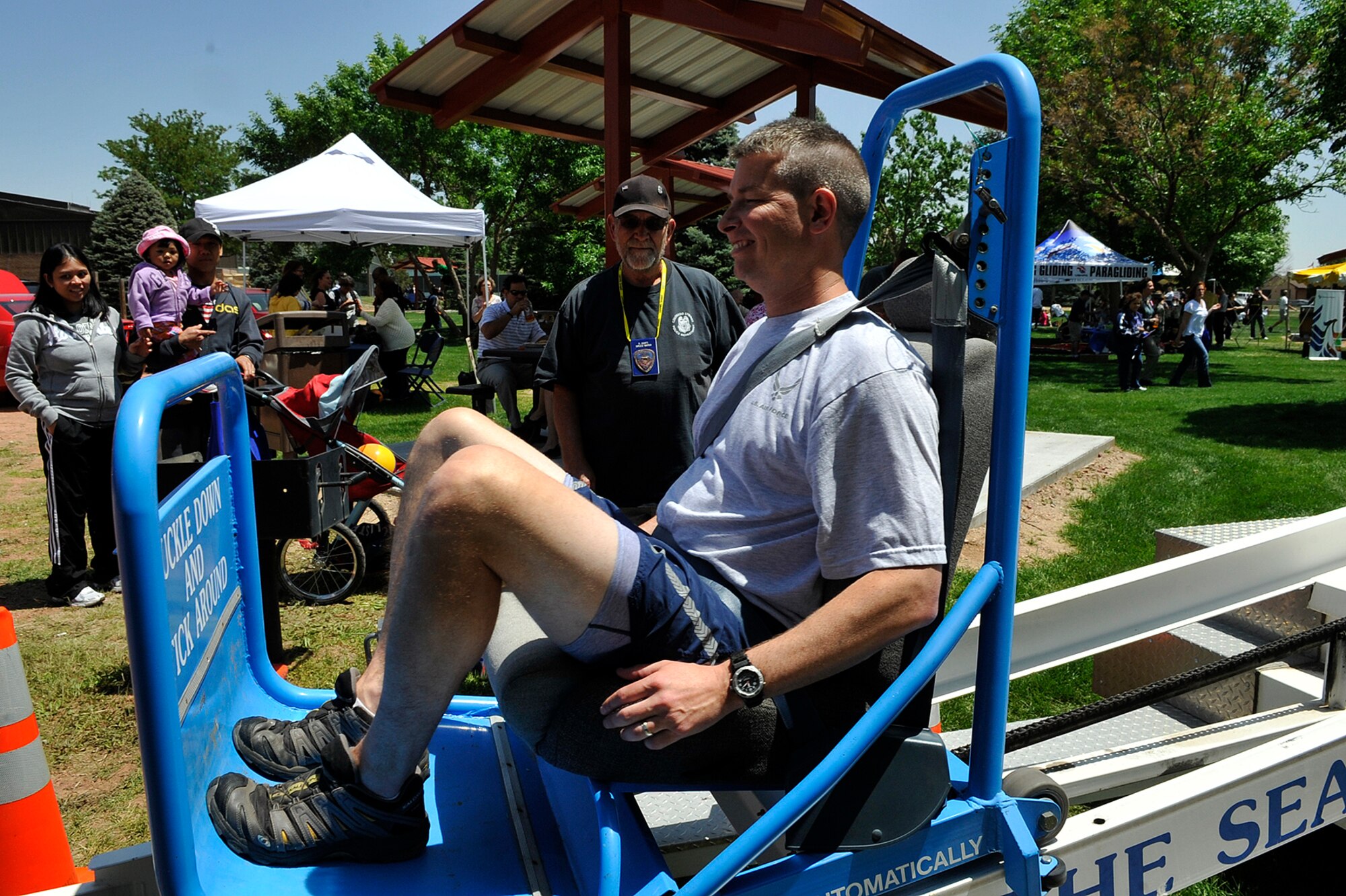 Col. Jeffrey Flewelling, the new 21st Space Wing vice commander, rides the Colorado Springs Police Department’s “Seat Belt Convincer” as volunteer Robert Scott looks on during Peterson Air Force Base’s Sports and Field Day June 9, 2011. The Seatbelt Convincer allows riders to experience force, up to five times their body weight, similar to that of a 5-7 mph crash. The machine was sponsored by the 21st SW Safety Office as part of the Critical Days of Summer safety campaign, which runs now to Labor Day weekend in September. (U.S. Air Force photo/Rob Bussard)
