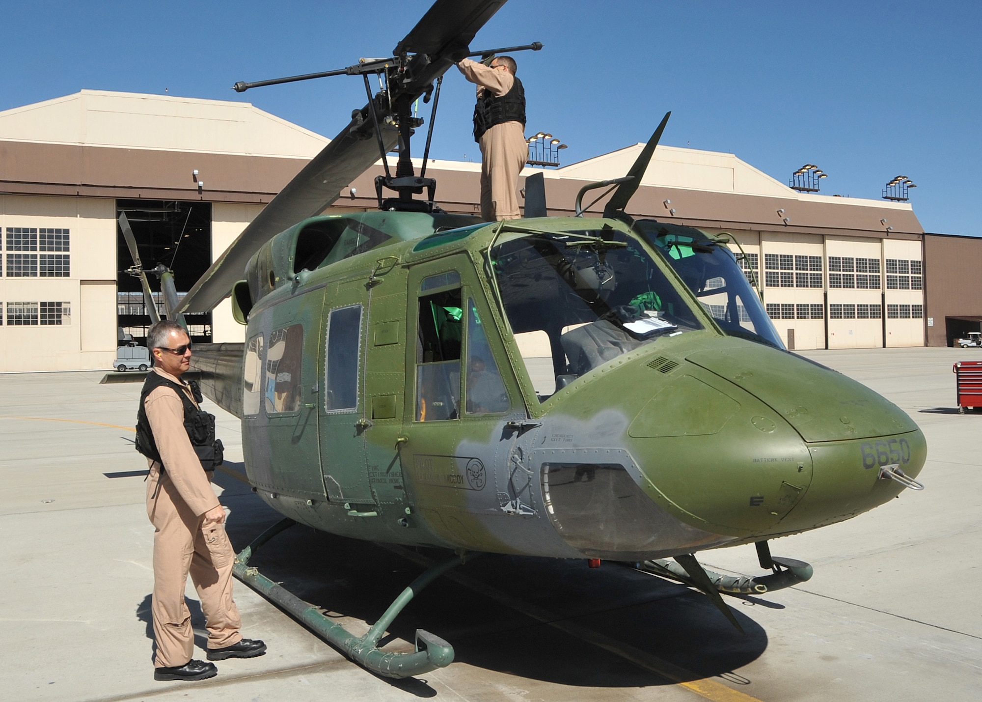 Retired Lt. Col. Kenneth Witte, left, along with retired Master Sgt. Robb Klein, right, performed a preflight inspection of the “Huey” helicopter before it embarked on its historic journey.