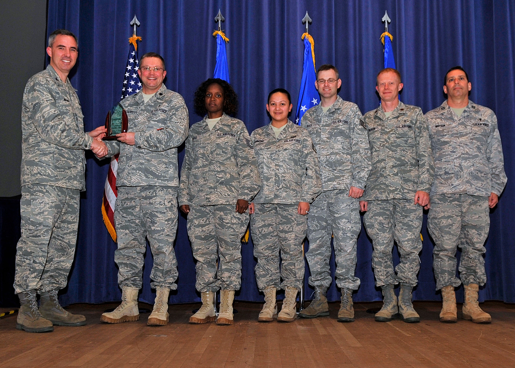 Col. Stephen N. Whiting (left), 21st Space Wing commander, presents Chaplain (Lt. Col.) Randall Kitchens, 21st SW Chaplain, and the chapel staff with the 2010 Terence P. Finnegan Award for medium-size chapels in Air Force Space Command during a recent commander’s call. This is the second consecutive year the 21st SW Chapel received the award. (U.S. Air Force photo/Rob Bussard) 
