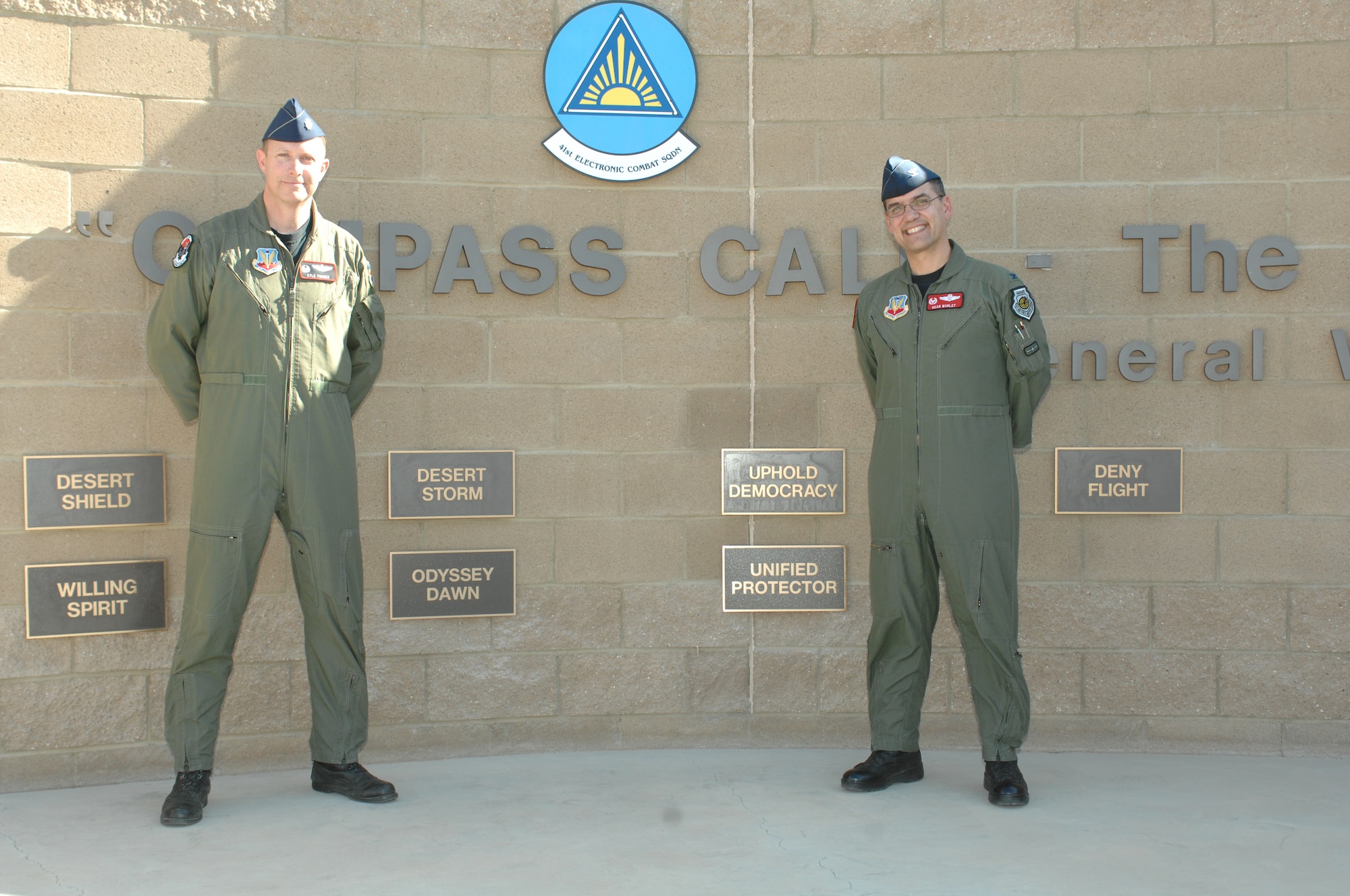 Lt. Col. Kyle Forrer (left) and Col. Dean Worley (right) stand beside the newly unveiled plaques on the 55th Electronic Combat Group Heritage Wall. Operations ODDYSEY DAWN and UNIFIED PROTECTOR are the 14th and 15th plaques to be added to the Heritage Wall.