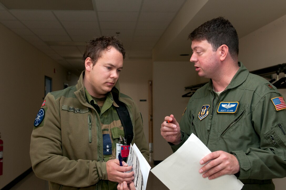 KEFLAVIK, Iceland -- Maj. Scott Clark (right), 756th Air Refueling Squadron pilot and exercise detachment commander, coordinates ground communications with 1st Lt. Kim Bruvik, Royal Norwegian Air Force flight controller, during the 2011 Northern Viking exercise here June 9. Northern Viking tests the capabilities of Iceland and the country's NATO allies, as well as "increase the readiness of the forces involved and their interoperability." The Reserve 459th Air Refueling Wing, Joint Base Andrews, Md., participated in this year's exercise along with other active-duty and Air National Guard units. (U.S. Air Force photo released/Tech. Sgt. Steve Lewis)