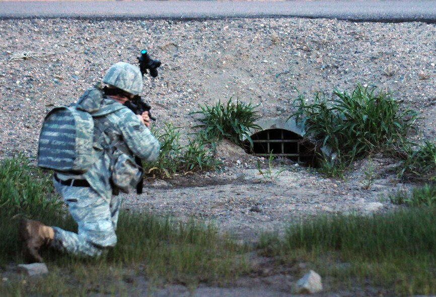 A member of the 90th Security Forces Group takes aim on a culvert, a possible hiding spot, with his M-4 June 4, during an exercise that was part of the Nuclear Surety Inspection. (U.S.Air Force photo by R.J. Oriez)