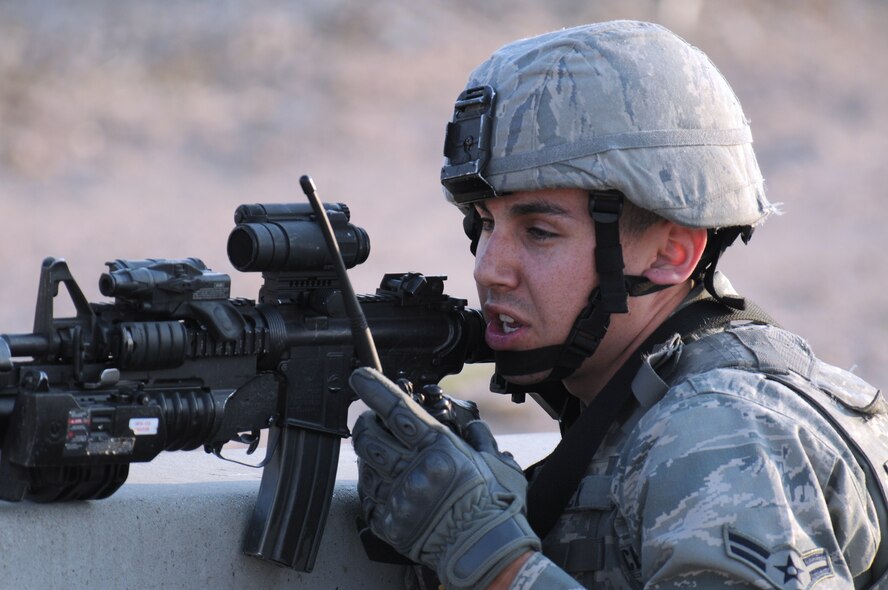An Airman with the 90th Security Forces Group uses the scope on his M-4 to look downrange and uses a radio to report back what he finds June 4, during an exercise that was part of the Nuclear Surety Inspection. The M-4 has a M203 grenade launcher attached. (U.S.Air Force photo by R.J. Oriez)
