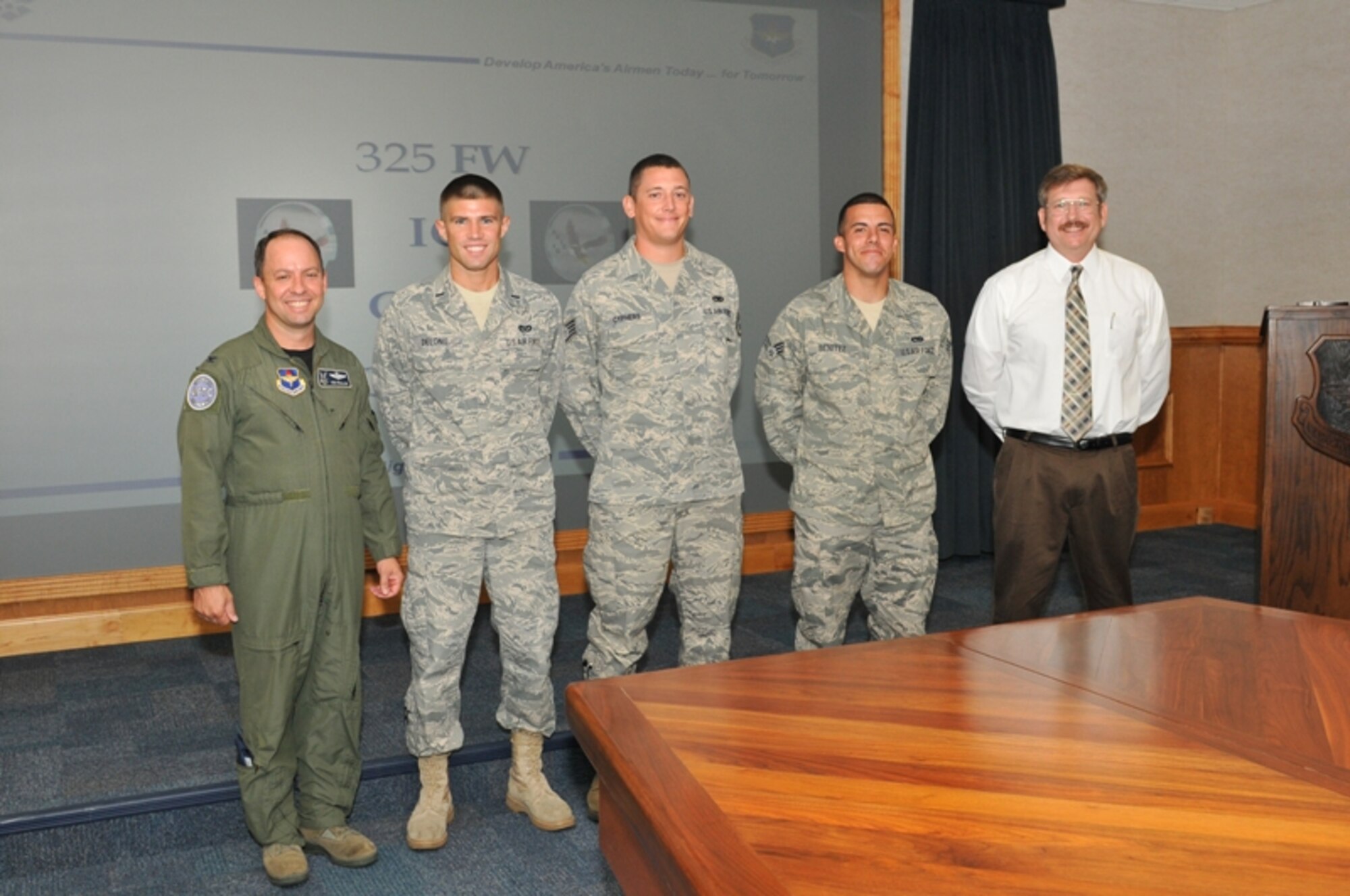 Colonel Ken Follini, Air Education and Training Command Inspector General inspection division chief, presented Inspector General coins to (left to right) 1st Lt. Branden DeLong, 325th Civil Engineer Squadron, Staff Sgt. William Cyphers, 325th Maintenance Squadron, Senior Airman Fredy Benitez, 325th MXS, and to Mr. Frank Labroad, 325th Fighter Wing, for outstanding performance during the 2011 AETC Compliance Inspection June 6 to 13. (U.S. Air Force photo by Lisa Norman) 