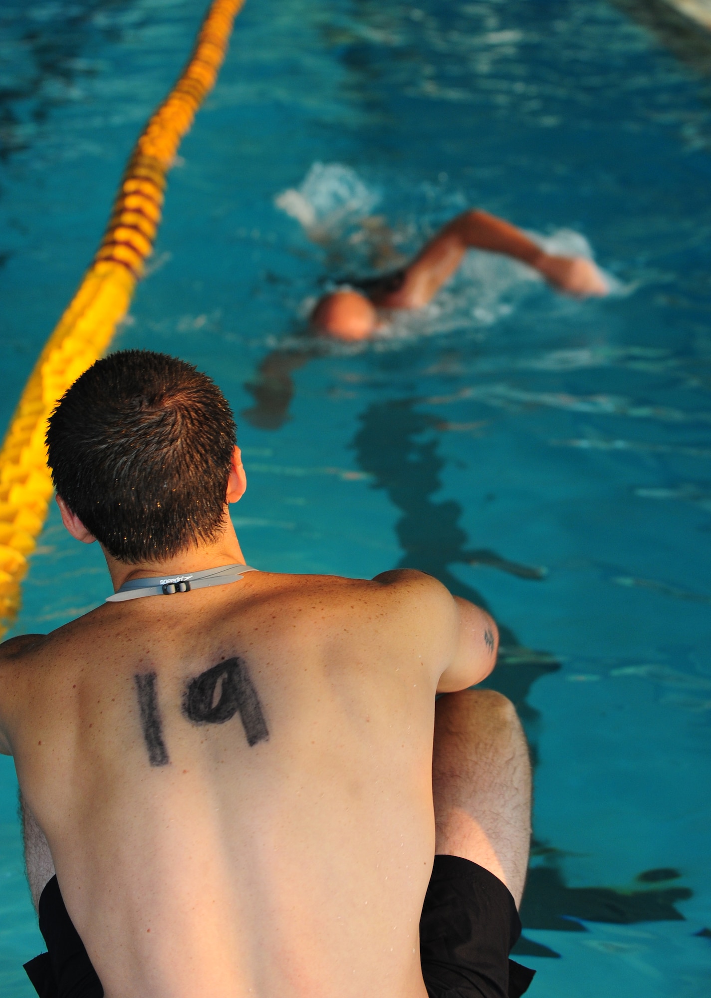 U.S. Air Force recruit Gabriel Fisher helps a fellow recruit by counting his laps during the swimming portion of a physical ability and stamina test during the Battlefield Airman Camp at Moody Air Force Base, Ga., June 10, 2011. The PAST consisted of a 500-meter swim, 1.5-mile run, two minutes of sit-ups and push-ups and one minute of pull-ups. (U.S. Air Force photo by Senior Airman Stephanie Mancha/Released)