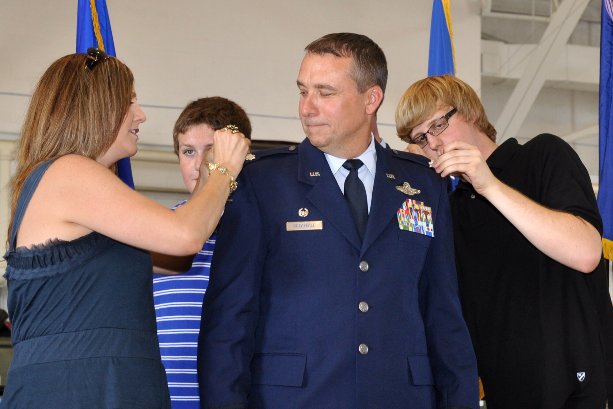Rhett Breazeale looks on as his mother Karen Breazeale and his brother Ryker remove rank insignia on an epaulet of his father, Lt. Col. John Breazeale, during the pinning-on ceremony held Friday, June 10, 2011, in the A-10 hangar at Barksdale Air Force Base, La. After being promoted, Colonel Breazeale assumed command of the 917th Fighter Group at Barksdale. Colonel Eric Overturf was the presiding official for the ceremony. Approximately 70 family members, friends and civic leaders were in attendance for the event. (U.S. Air Force photo/Tech. Sgt. Jeff Walston)