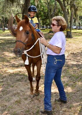 A little boy goes for a horseback ride at the Team Eglin Picnic at Post’l Point June 10.  Eglin personnel and their families enjoyed an afternoon complete with food, beverages and activities, including a water slide, bouncy house, climbing wall, face painting and horseback riding. (U.S. Air Force photo/Kevin Gaddie)
