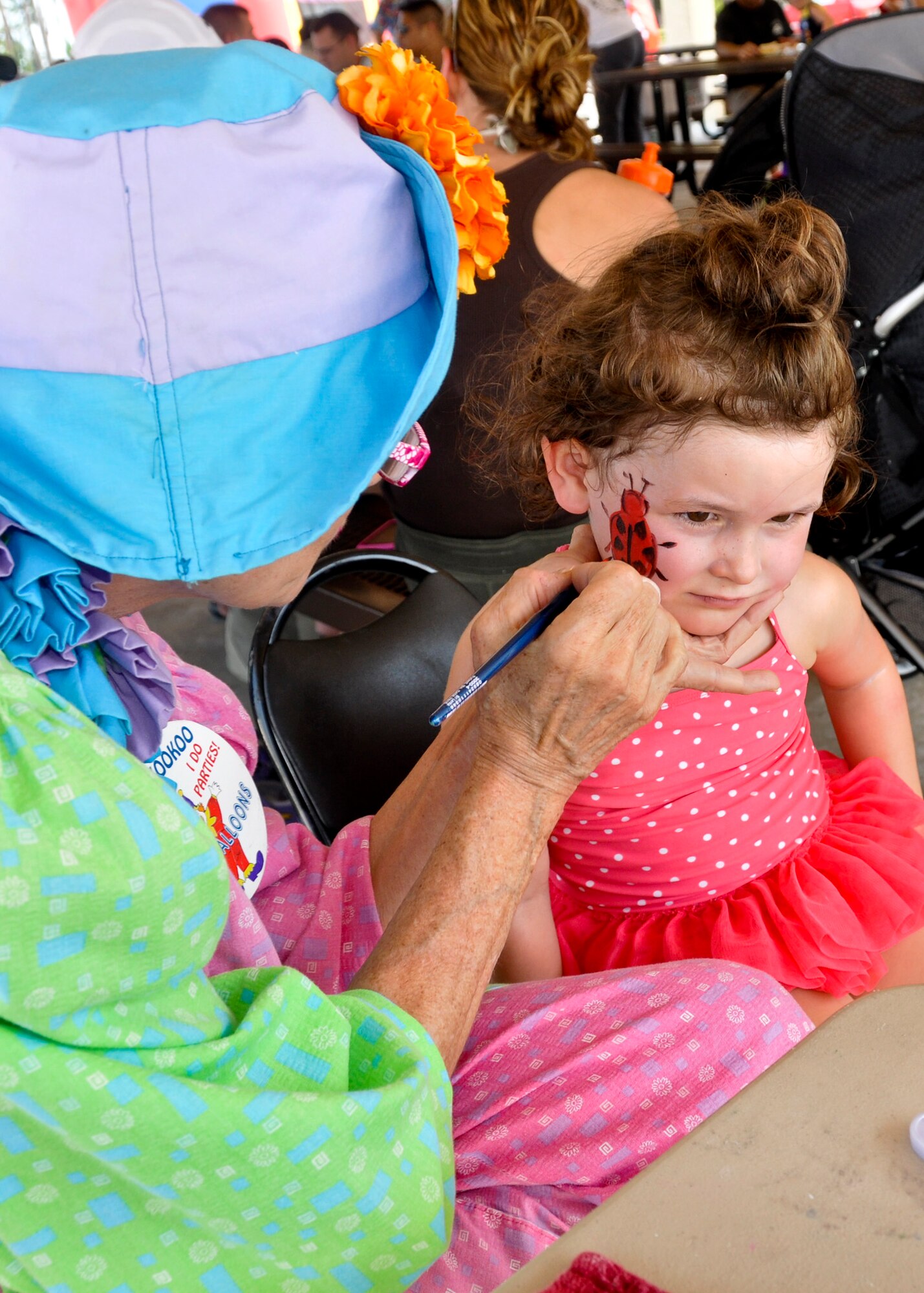 A little girl has a ladybug painted on her face at the Team Eglin Picnic at Post’l Point June 10.  Eglin personnel and their families enjoyed an afternoon complete with food, beverages and activities, including a water slide, bouncy house, climbing wall, face painting and horseback riding. (U.S. Air Force photo/Kevin Gaddie)
