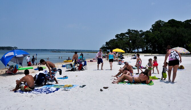 Beach goers bask in the sunshine at the Team Eglin Picnic at Post’l Point June 10.  Eglin personnel and their families enjoyed an afternoon complete with food, beverages and activities, including a water slide, bouncy house, climbing wall, face painting and horseback riding. (U.S. Air Force photo/Kevin Gaddie)
