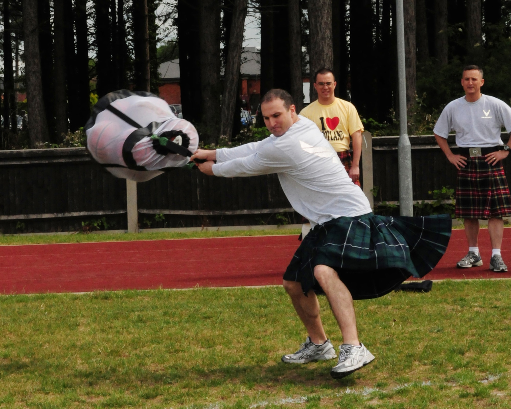 RAF MILDENHALL, England -- Maj. Adrian Hageman, 100th Force Support Squadron commander, swings a bag of basketballs during the basketball toss event amid the Team Mildenhall Olympic Sports Challenge June 10, 2011. Participants were required to wear kilts for the event. Major Hageman placed second in the event; Master Sgt. Michael Bitson, 100th Communications Squadron, placed first, and Staff Sgt. Thomas Long, 352nd Special Operations Maintenance Squadron, came in third. Competitors had to swing and throw a bag full of basketballs across a marked area of the field. (U.S. Air Force photo/Karen Abeyasekere)
