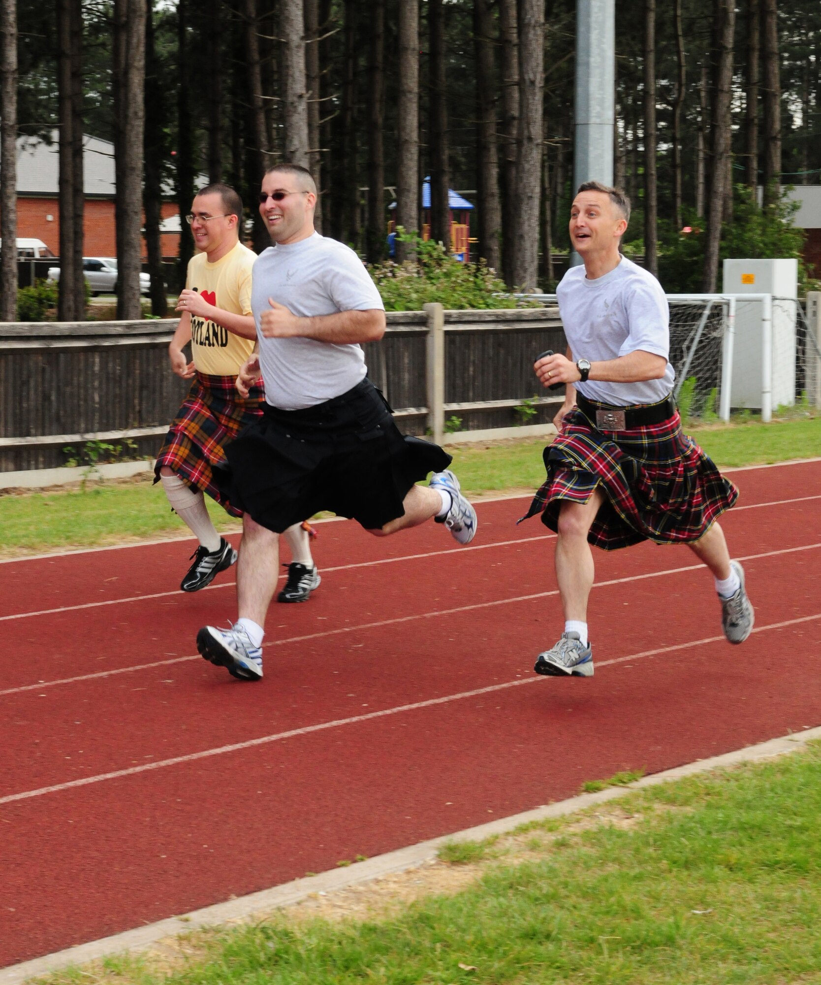 RAF MILDENHALL, England -- (Left to right) Staff Sgt. Thomas Long, 352nd Special Operations Maintenance Squadron; Master Sgt. Michael Bitson, 100th Communications Squadron; and Lt. Col. Gene Mattingly, 100th CS commander, dash for the finish line during the Kilt Run event at the Team Mildenhall Olympic Sports Challenge June 10, 2011. Participants had to wear a kilt and run one lap of the track at Heritage Park. Sergeant Long placed first, Sergeant Bitson came in second and Colonel Mattingly was third. (U.S. Air Force photo/Karen Abeyasekere)