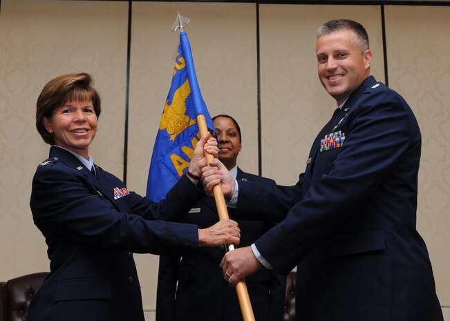 Col. Consuella Pockett passes the guidon to Lt. Col. Devin Beckstrand during the 628th Aerospace Medicine Squadron Change of Command at Joint Base Charleston June 13. Colonel Pockett is the 628th Medical Group commander and Colonel Beckstrand is the new 628 AMDS commander. (U.S. Air Force photo/Staff Sgt. Katie Gieratz)