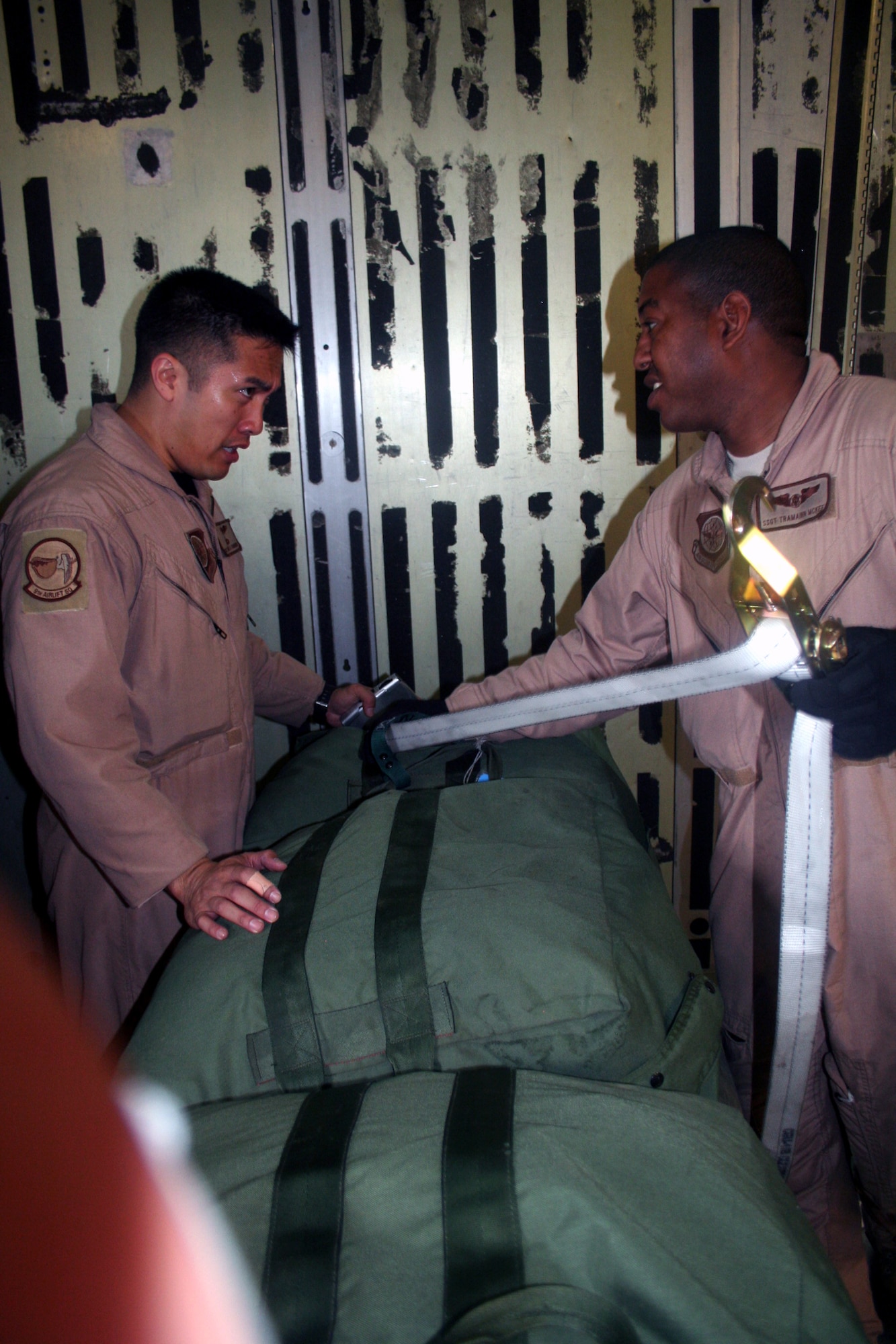 Staff Sgts. Tramainn McKee and Angelo Dumanhog, both C-5 Galaxy loadmasters, work in a C-5M Super Galaxy on June 5, 2011, prior to departing for a direct delivery airlift mission through the Arctic Circle from Dover Air Force Base, Del., to Bagram Airfield, Afghanistan. Sergeants McKee and Dumanhog were among 14 crewmembers who flew the mission. They are from the 9th Airlift Squadron at Dover AFB.  (U.S. Air Force Photo/Master Sgt. Scott T. Sturkol)