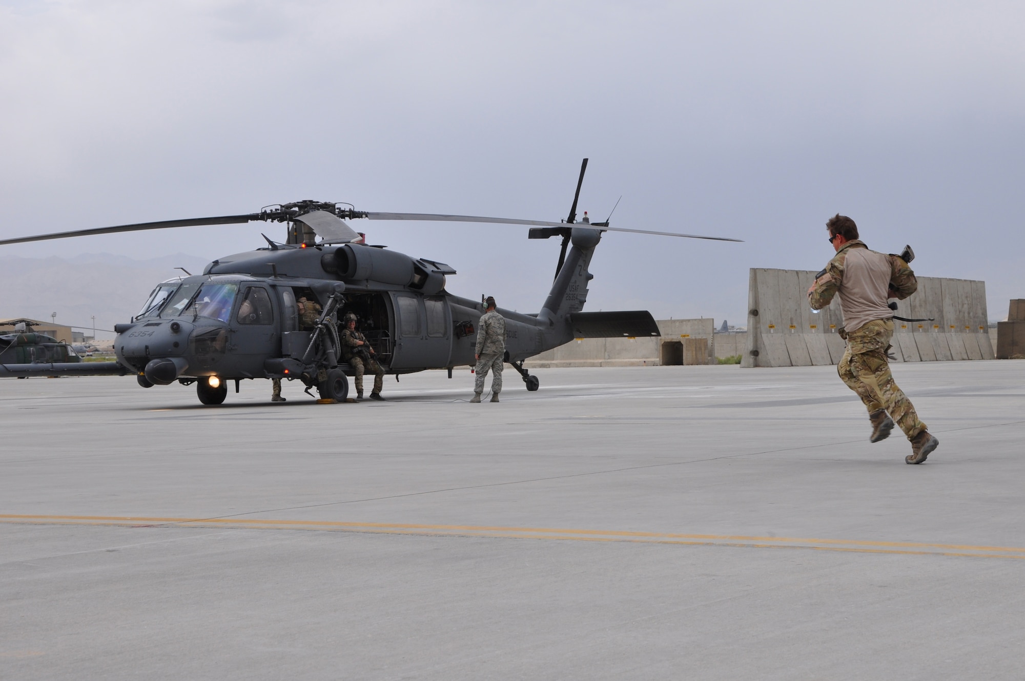 BAGRAM AIRFIELD, Afghanistan -- Tech. Sgt. Kris Burridge, 83rd Expeditionary Rescue Squadron pararescue jumper, wastes no time in getting out to a HH-60G Pave Hawk helicopter during a casualty evacuation mission here June 11. The quick response actions of the 83rd ERQS Airmen saved the lives of two wounded Afghan National Police in Kapisa Province, Afghanistan. It takes the 83rd ERQS an average of just 10 minutes from the time of notification to have a helicopter on its way to the fight. Sergeant Burridge is from Detroit, Mich. The 83rd ERQS pararescue Airmen are deployed from the 31st Rescue Squadron at Kadena Air Base; the aircrew are deployed from the 33rd Rescue Squadron, also at Kadena Air Base. (U.S. Air Force photo by Staff Sgt. John Wright)