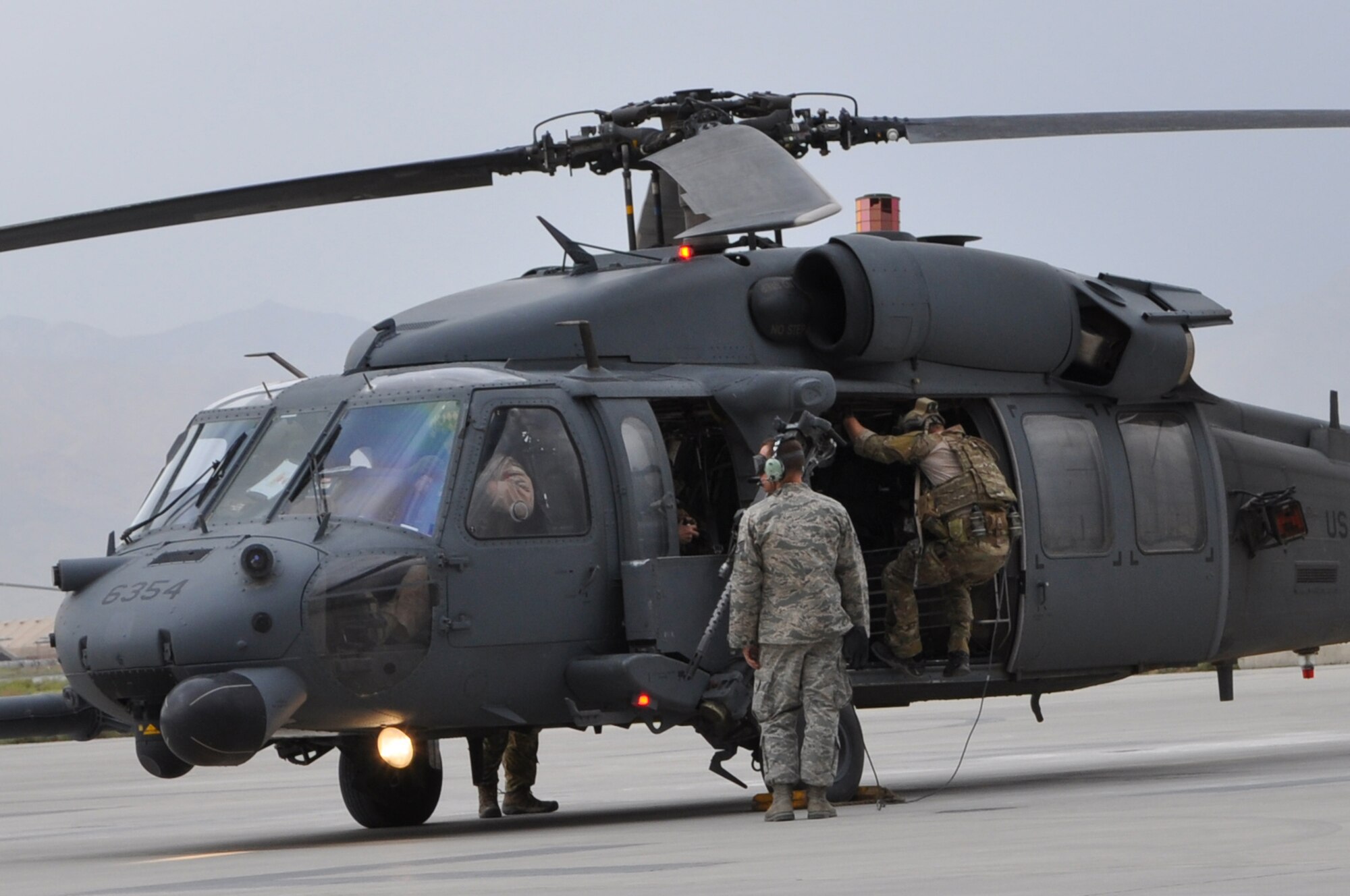 BAGRAM AIRFIELD, Afghanistan -- A pararescue Airman from the 83rd Expeditionary Rescue Squadron scrambles inside a HH-60G Pave Hawk helicopter after receiving an alert call here June 11. The helicopter was in the air on a life-saving casualty evacuation mission within 10 minutes of receiving the call. The quick response actions of the 83rd EPRS Airmen saved the lives of two wounded Afghan National Police in Kapisa Province, Afghanistan. The 83rd ERQS pararescue Airmen are deployed from the 31st Rescue Squadron at Kadena Air Base; the aircrews are deployed from the 33rd Rescue Squadron, also at Kadena Air Base. (U.S. Air Force photo by Staff Sgt. John Wright)