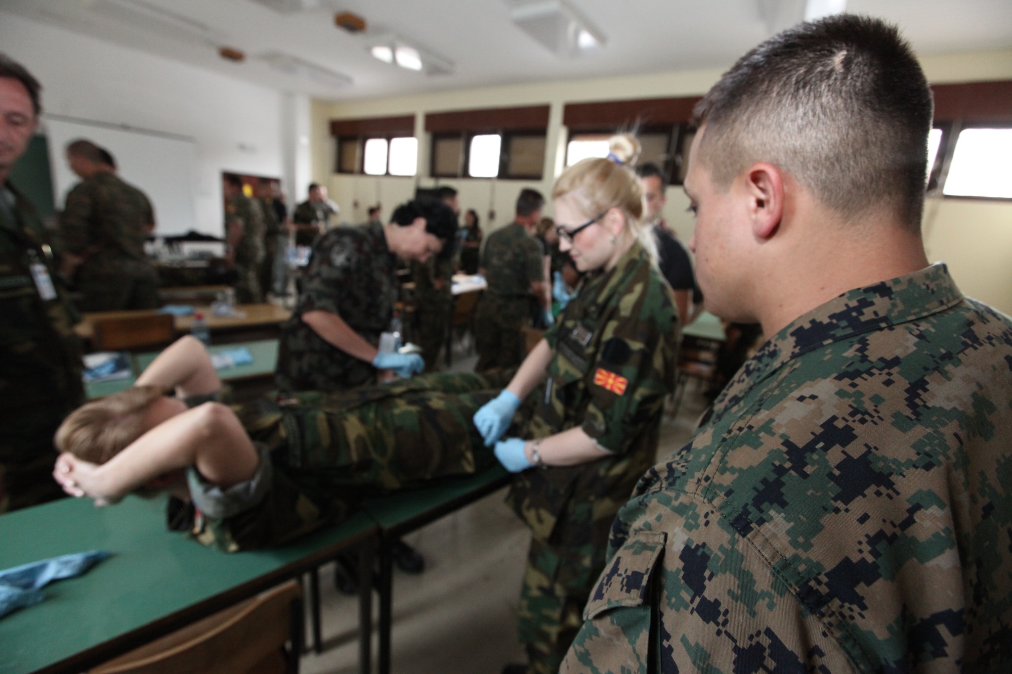 CAMP PEPELISHTE, Macedonia – Sgt. Sergio Rosas, a Personnel and Retrieval Processing specialist, observes as multinational students work together during the practical portion of the mortuary affairs brief led by the U.S. Marines from Personnel and Retrieval Processing Company, 4th Marine Logistics Group, out of Smyrna, Ga., and Anacostia, Washington, D.C., here June 10.  This brief was to teach multinational partners on how the Marine Corps processes human remains and conducts search and recovery missions.  The Marines came to Macedonia for Medical Training Exercise in Central and Eastern Europe 2011 to teach multinational partners how to conduct mortuary affairs. MEDCEUR is an annual Chairman of the Joint Chiefs of Staff-sponsored regional and multilateral exercise and is designed to provide medical training and operational experience in a deployed environment for U.S. and partner nations. The countries participating in this year’s MEDCEUR are Macedonia, Montenegro, Bosnia and Herzegovina, Serbia, Slovenia and Norway.  The exercise will include both classroom and hands-on training and run until June 15.