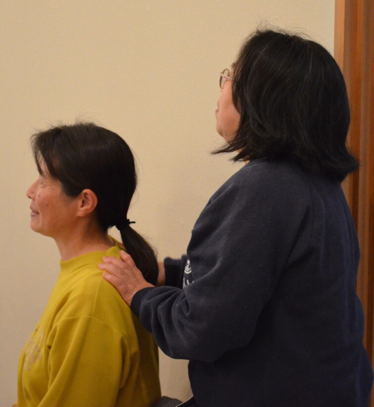 Two audience members share a moment of consolation during an AF Band of the Pacific-Asia performance in Miyako City in June 2011.