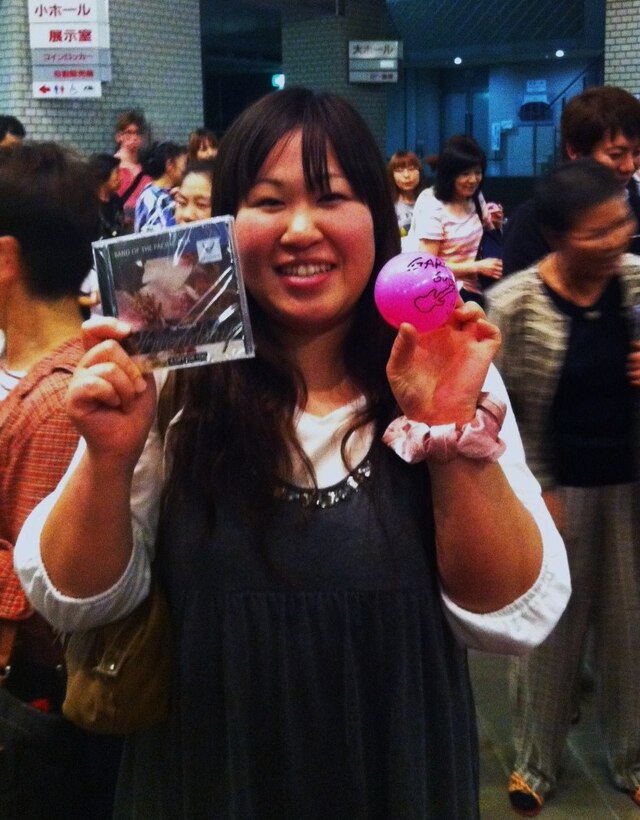 An audience member displays a CD and autographed souvenir she received after an AF Band of the Pacific-Asia performance in the Sendai area, June 2011.