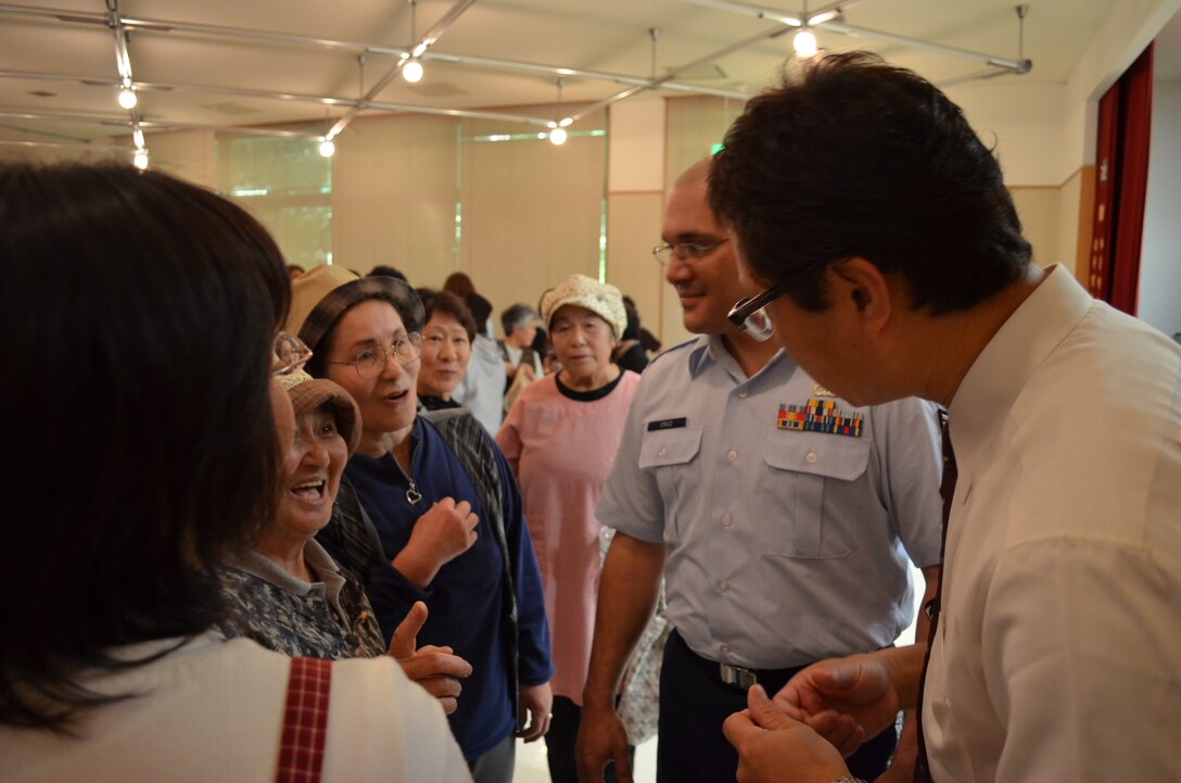SrA Wilfredo Cruz and Community Relations Specialist Mr. Masato Yagi talk with audience members after an AF Band of the Pacific-Asia performance at Taro Town Welfare Center in Miyako City in June 2011.