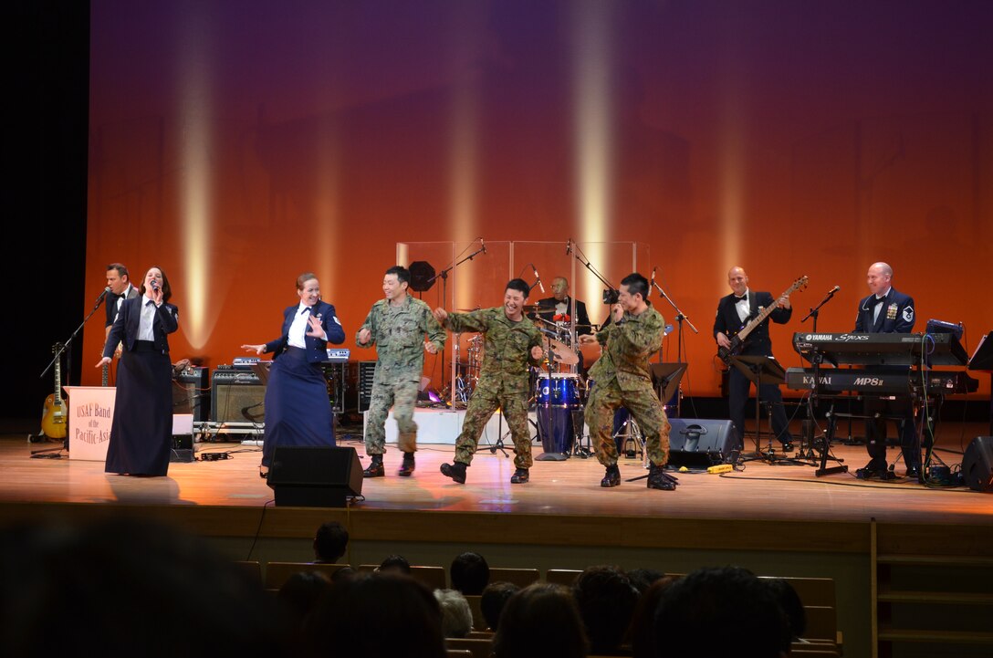 Members of the Japanese Ground Self Defense Force dance on stage with band members in Taiwa Town, Miyagi Prefecture