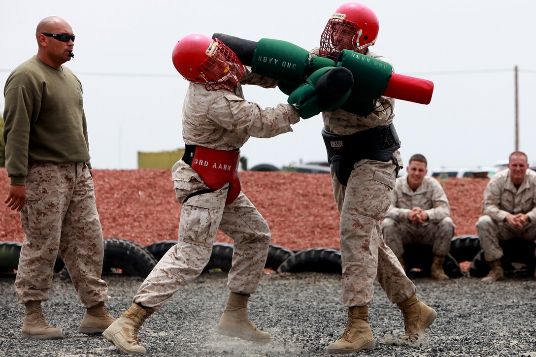 Two Marines from 3d Assault Amphibian Battalion face off against each other during a pugil stick match as an instructor looks on to keep score of hits during a Marine Corps Martial Arts Program at Camp Pendleton, June 15. Throughout the MCMAP course students are pushed physically to ensure they have the proper stamina to endure close quarter combat situations.