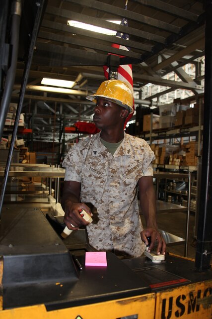 Cpl. James H. Taggart JR. works with a fork lift to pick up pallets full of mess hall gear and places them on the shelves June 14.