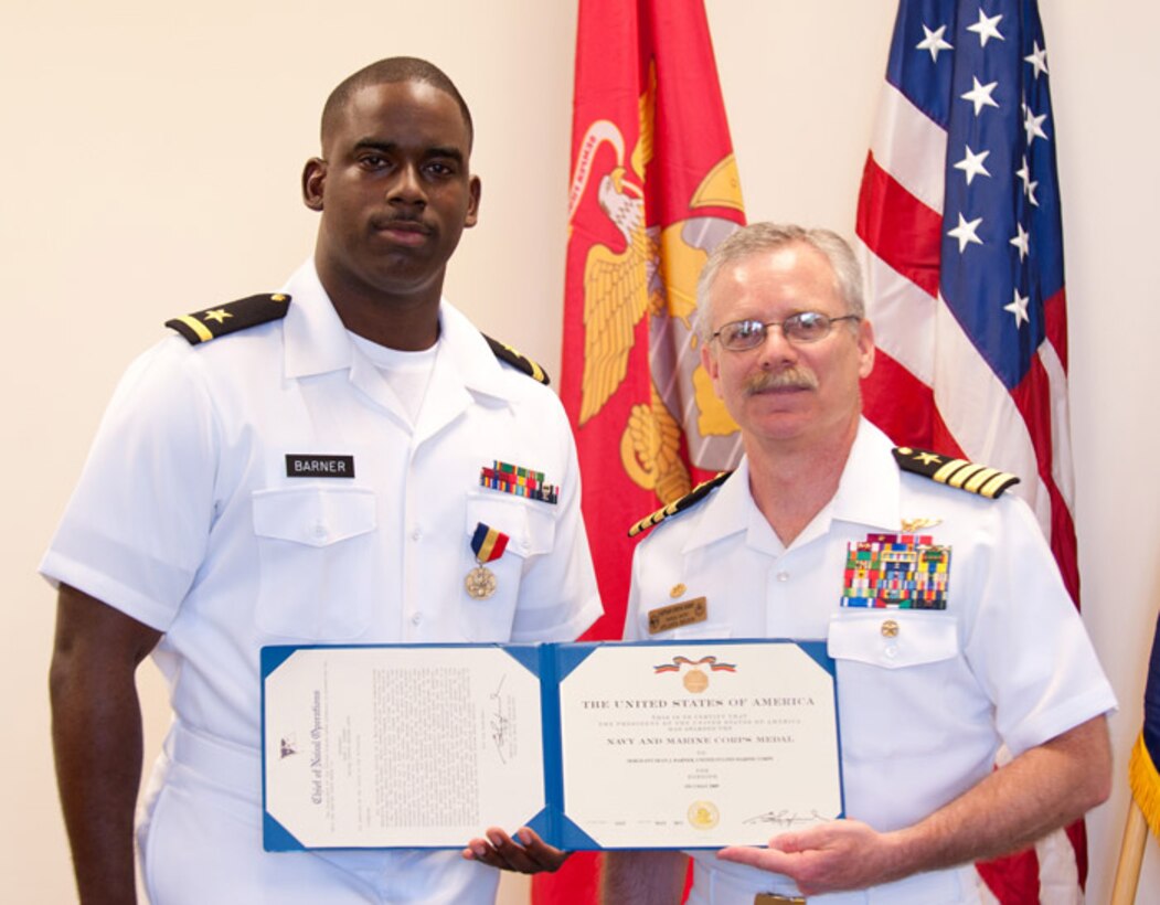 Ensign Sean Barner is presented with the Navy and Marine Corps medal by Capt. Steve Kirby, commanding officer of the NROTC Atlanta Consortium, June 14, in the O’Keefe Building’s Joint Forces auditorium on the campus of Georgia Institute of Technology (Georgia Tech). The Navy and Marine Corps medal is the highest non-combat honor that can be bestowed on a Sailor or Marine. Barner received the medal for actions he took to prevent a rape and robbery on May 3, 2009 as a sophomore NROTC Midshipman at Georgia State University.