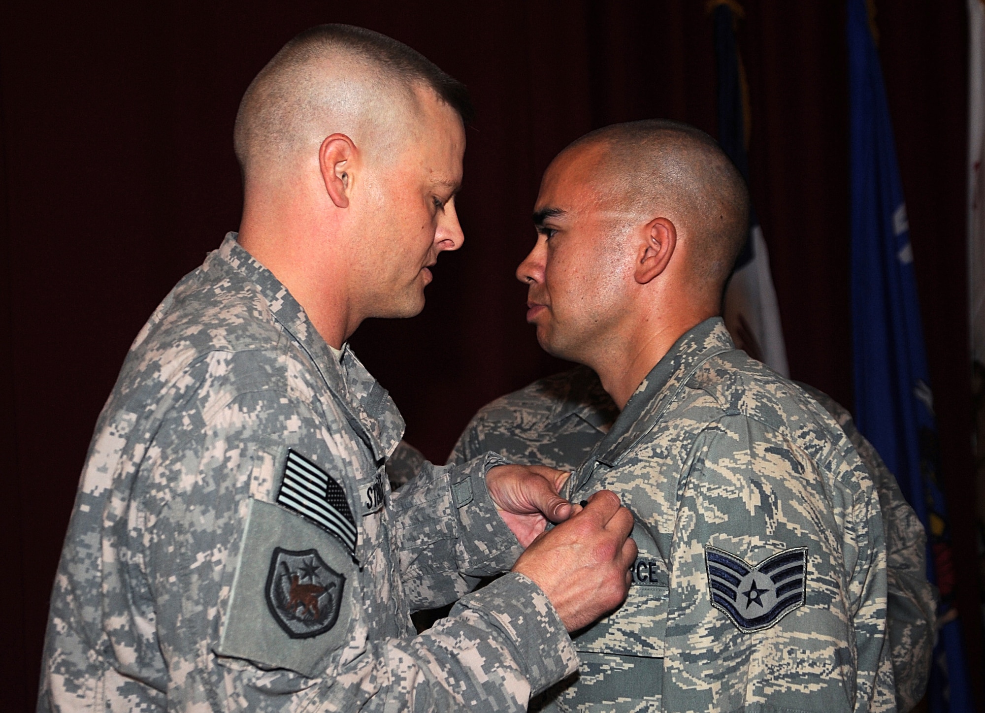 Air Force Staff Sgt. Lance Atkinson, right, receives the U.S. Army Combat Action Badge during an official ceremony in Southwest Asia June 9. Sergeant Atkinson is a combat trucker with the 387th Expeditionary Logistics Readiness Squadron. Sergeant Atkinson's vehicle was struck by an improvised explosive device while on a convoy in Iraq as part of the Joint Logistics Task Force 6, 70th Medium Truck Detachment in direct support of Operations New Dawn and Iraqi Freedom. (U.S. Air Force photo by Senior Airman Cynthia Spalding)