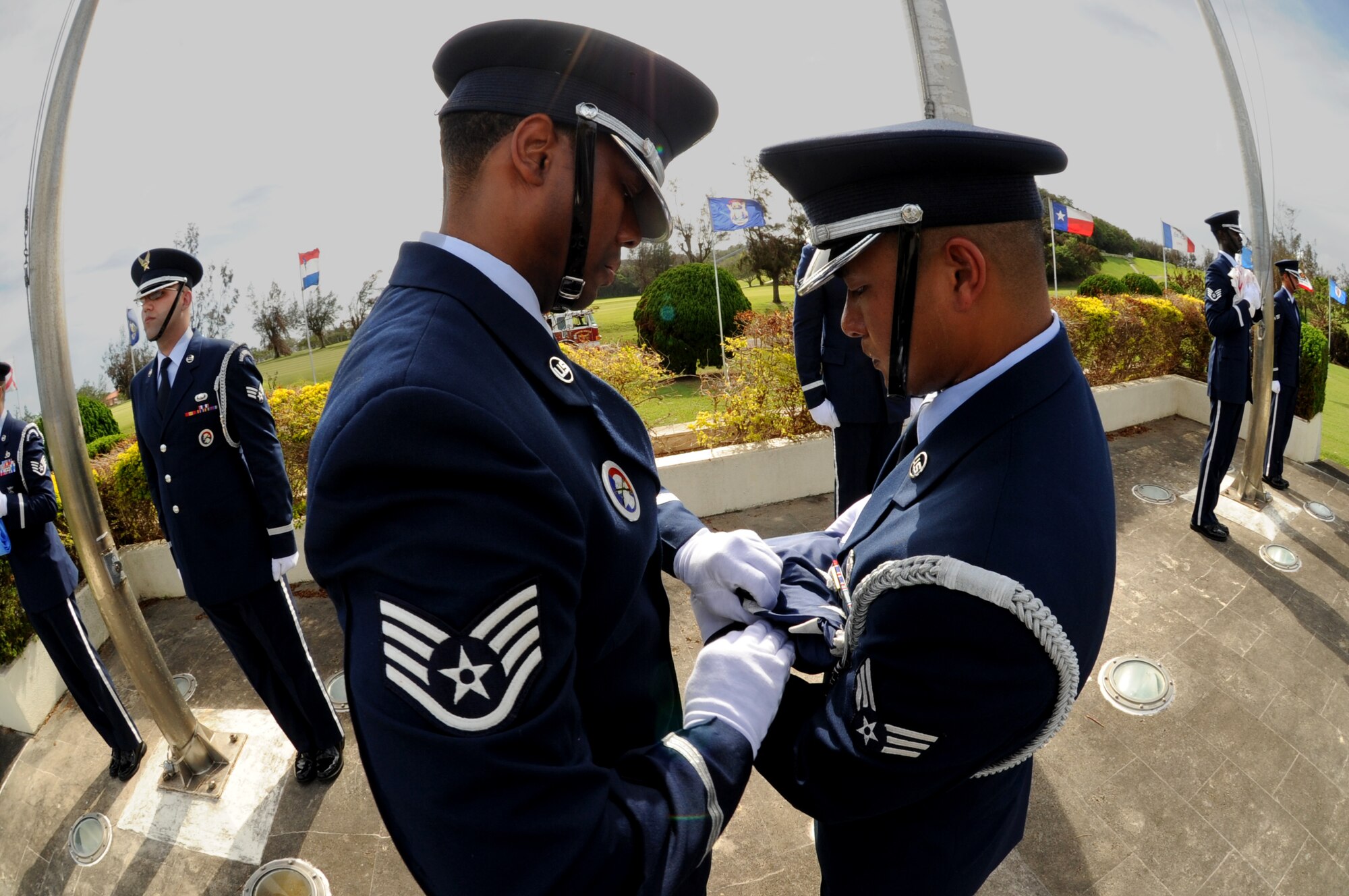 Kadena Honor Guardsmen Staff Sgt. Mario Rainge, 18th Civil Engineer Squadron, and Senior Airman Raymond Firme, 18th Component Maintenance Squadron, fold the American flag during the 2011 Air Force Sergeants Association’s Flag Day Ceremony, June 14, Kadena Air Base, Japan. During this ceremony out of service flags were retired by being burned. (U.S. Air Force photo/Airman1st Class Jarvie Z.Wallace) 
