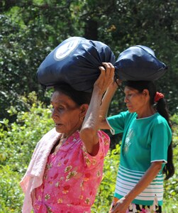 Villagers carry 40 pound bags of food given to them by Joint Task Force-Bravo Soldiers, Airmen, Sailors and Marines at a isolated village June 11, 2011, near Comayagua, Honduras. More than 120 JTF-B personnel hiked two miles up steep terrain to deliver food to people living in the town.  (U.S. Air Force photo/Tech. Sgt. Matthew McGovern)