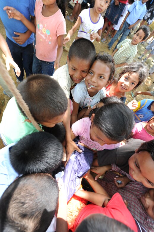 Children scramble for candy after a piñata breaks open at a isolated village June 11, 2011, near Comayagua, Honduras. More than 120 Joint Task Force Bravo personnel hiked two miles up steep terrain to deliver food to people living in the town. (U.S. Air Force photo/Tech. Sgt. Matthew McGovern)