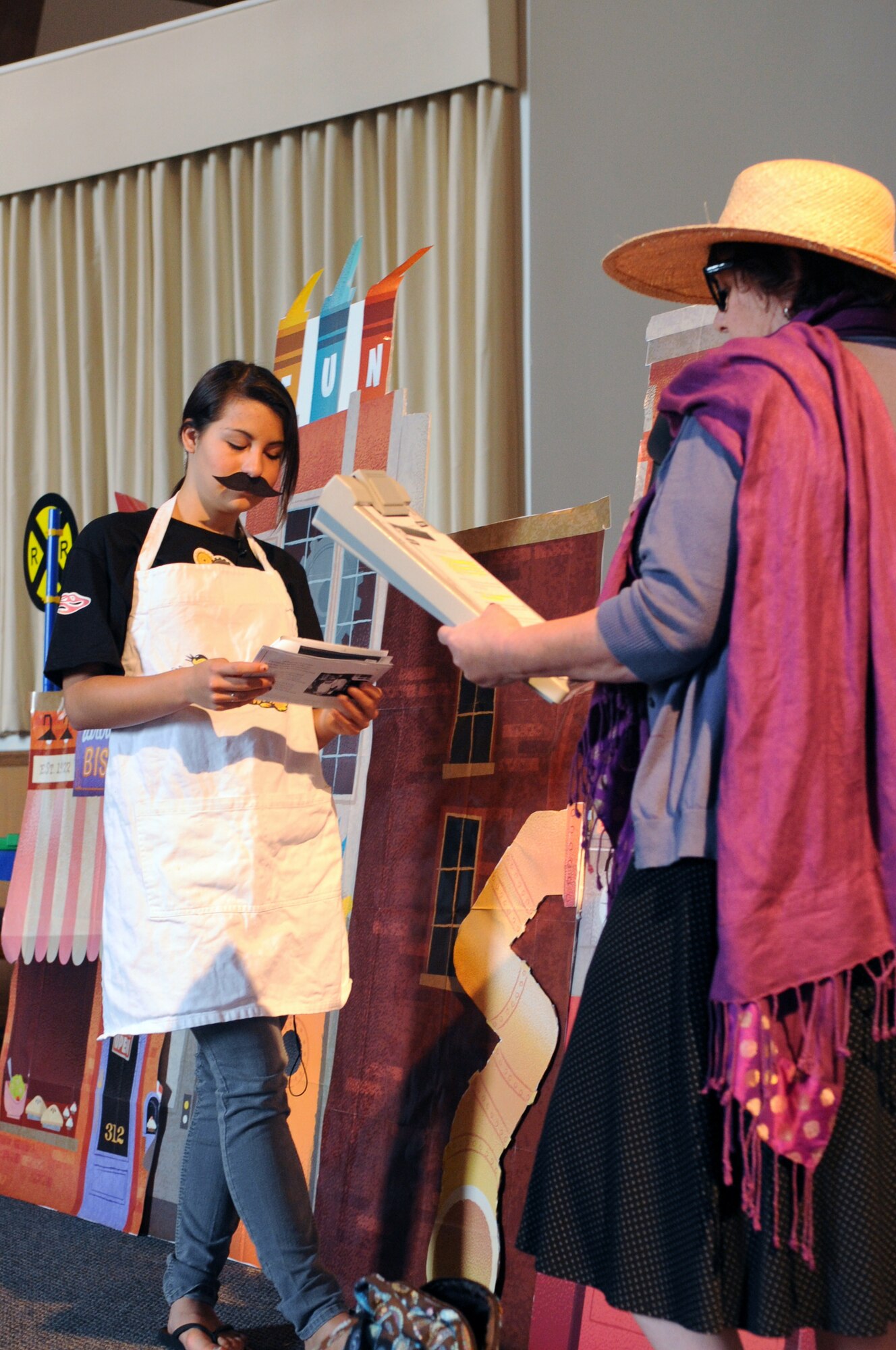 VANDENBERG AIR FORCE BASE, Calif. -- Diane Banner, from the Wing Chapel, and Isabel Colon, a teen volunteer, perform a skit during a Vacation Bible School class here Tuesday, June 14, 2011. This year’s “Inside Out & Upside Down on Main Street” themed VBS uses parables, to connect a Bible story and verse to the Word on the Street. Children of all religious backgrounds are invited to attend. (U.S. Air Force photo/Jerry E. Clemens, Jr.)