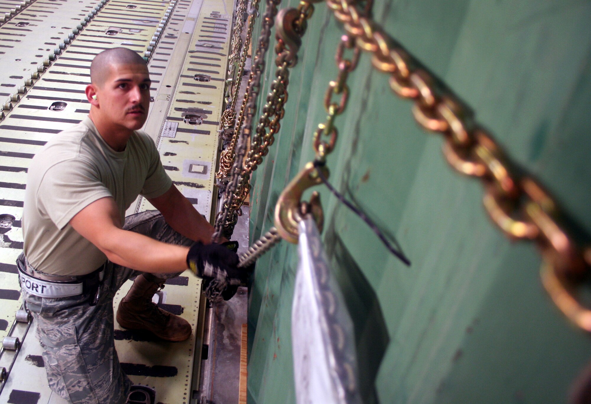 Airmen 1st Class Dustin Carlton, air transportation journeyman from the 436th Aircraft Aerial Port Squadron, checks on cargo on a C-5M Super Galaxy on June 5, 2011, prior to the plane's departure for a direct delivery airlift mission through the Arctic Circle from Dover Air Force Base, Del., to Bagram Airfield, Afghanistan. Airman Carlton is a native of Moore, Okla. (U.S. Air Force Photo/Master Sgt. Scott T. Sturkol)