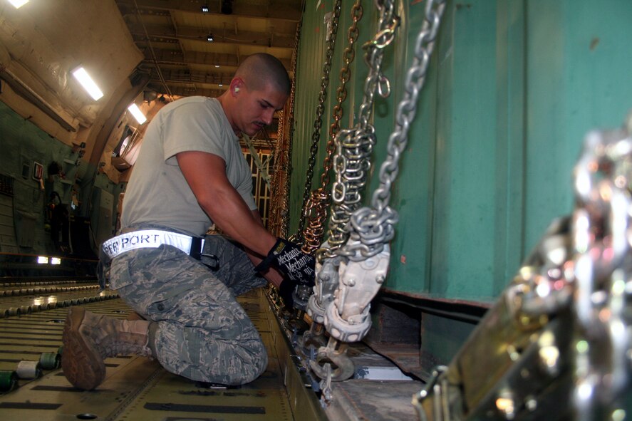 Airmen 1st Class Dustin Carlton, air transportation journeyman from the 436th Aircraft Aerial Port Squadron, checks on cargo on a C-5M Super Galaxy on June 5, 2011, prior to the plane's departure for a direct delivery airlift mission through the Arctic Circle from Dover Air Force Base, Del., to Bagram Airfield, Afghanistan. Airman Carlton is a native of Moore, Okla. (U.S. Air Force Photo/Master Sgt. Scott T. Sturkol)